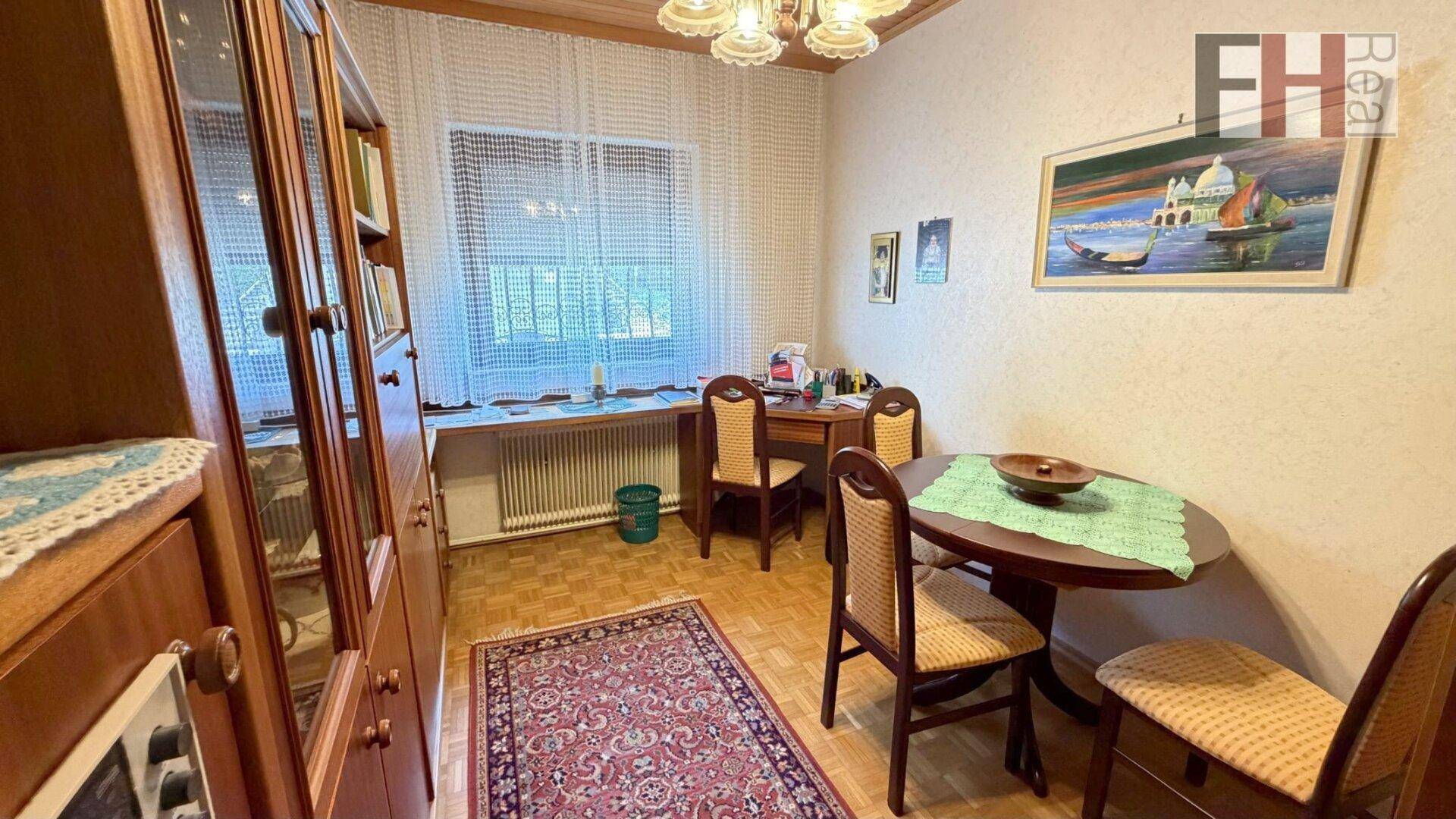 Gemütliches Arbeitszimmer mit Holzdecke, Parkettboden und traditionellen Möbeln.