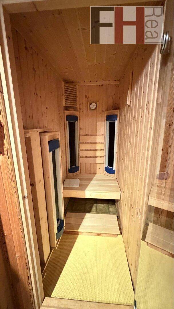 Innenansicht einer modernen Infrarotsauna mit Holzbänken und Heizstrahlern.