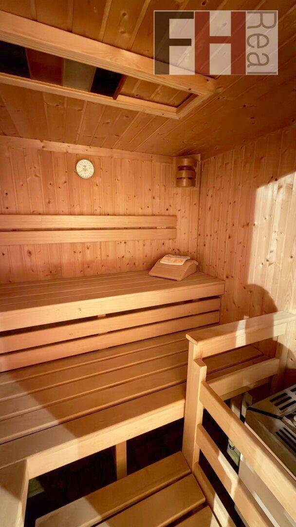 Traditionelle Holzsauna mit mehrstufigen Bänken und klassischem Saunaofen für Entspannung.