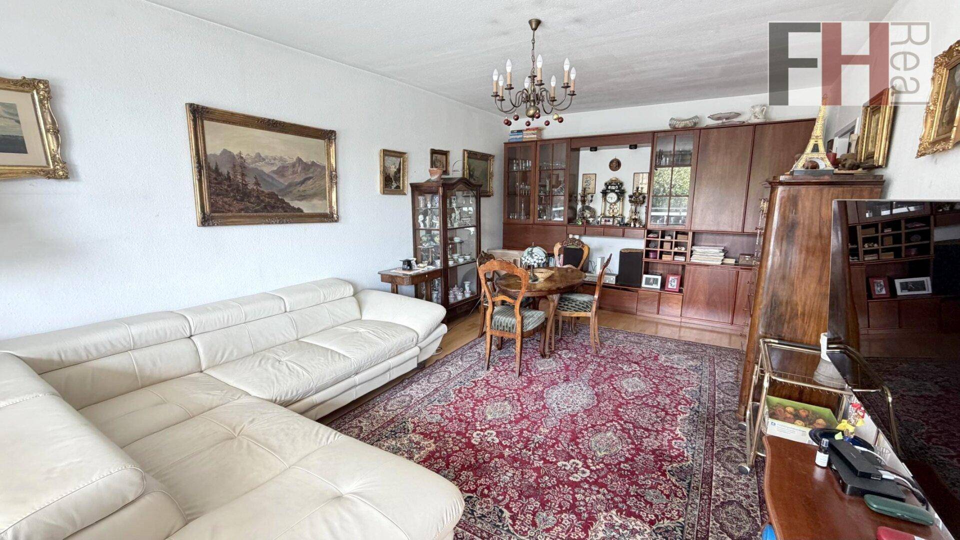 Geräumiger Wohn- und Essbereich mit bequemer Couch, Esstisch und traditionellen Holzmöbeln.