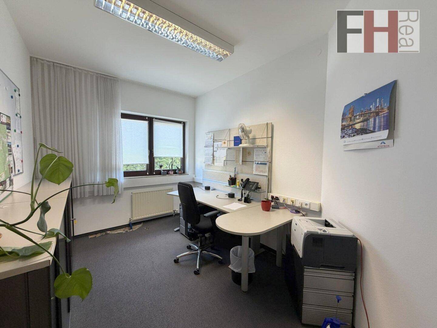 Einzelbüro mit Schreibtisch, Bürostuhl und Fenster mit Jalousien für Privatsphäre.