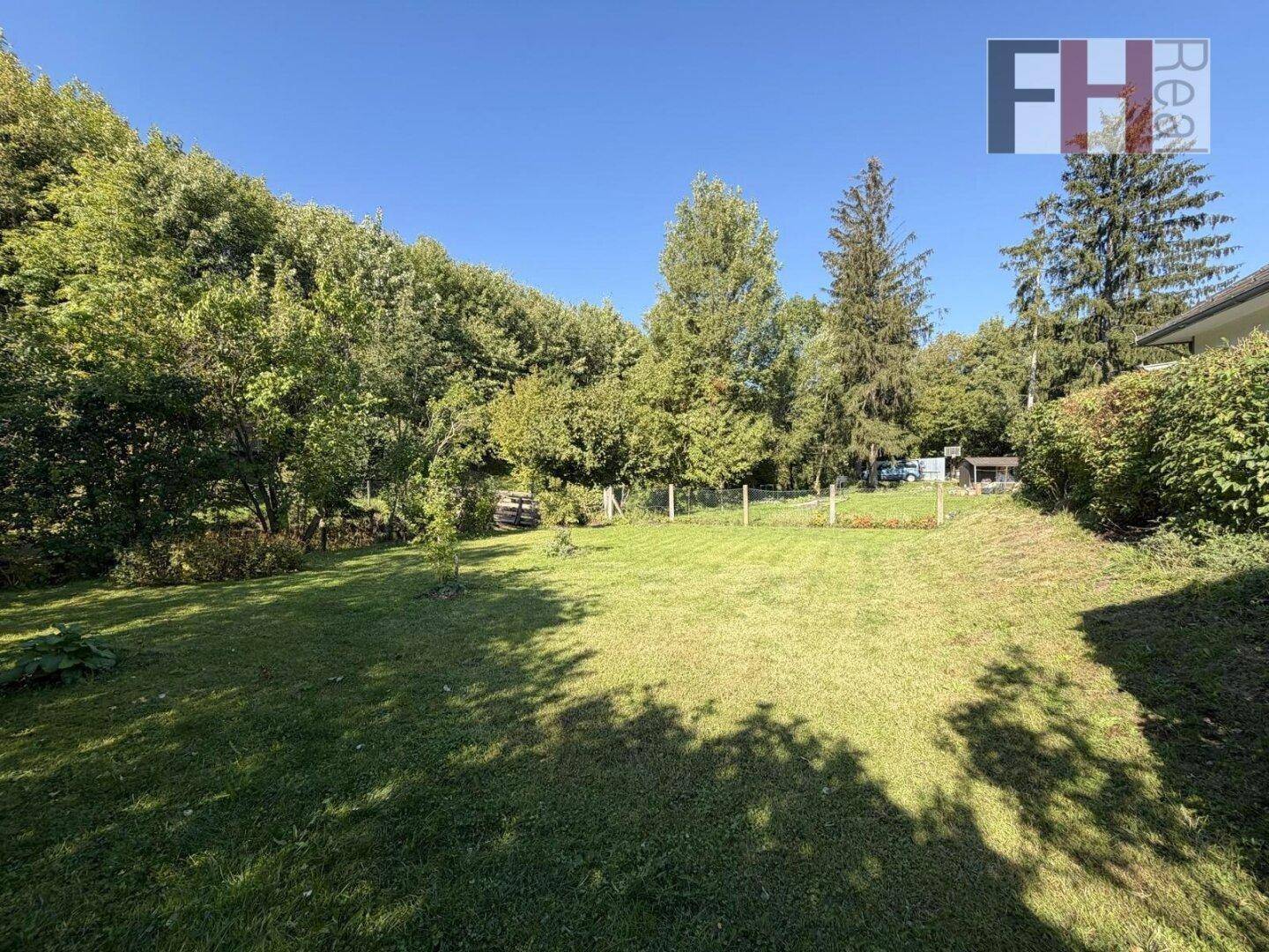 Großer, gepflegter Gartenbereich mit weitläufiger Rasenfläche und altem Baumbestand.