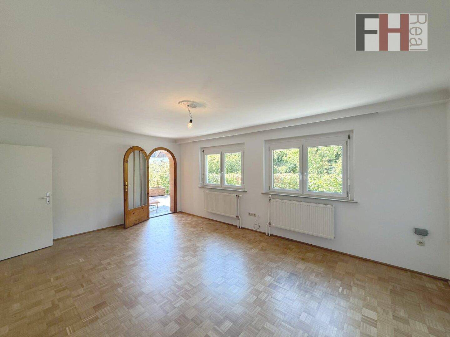 Helles Wohnzimmer mit Parkettboden und Zugang zur Terrasse, bereit zur individuellen Gestaltung.