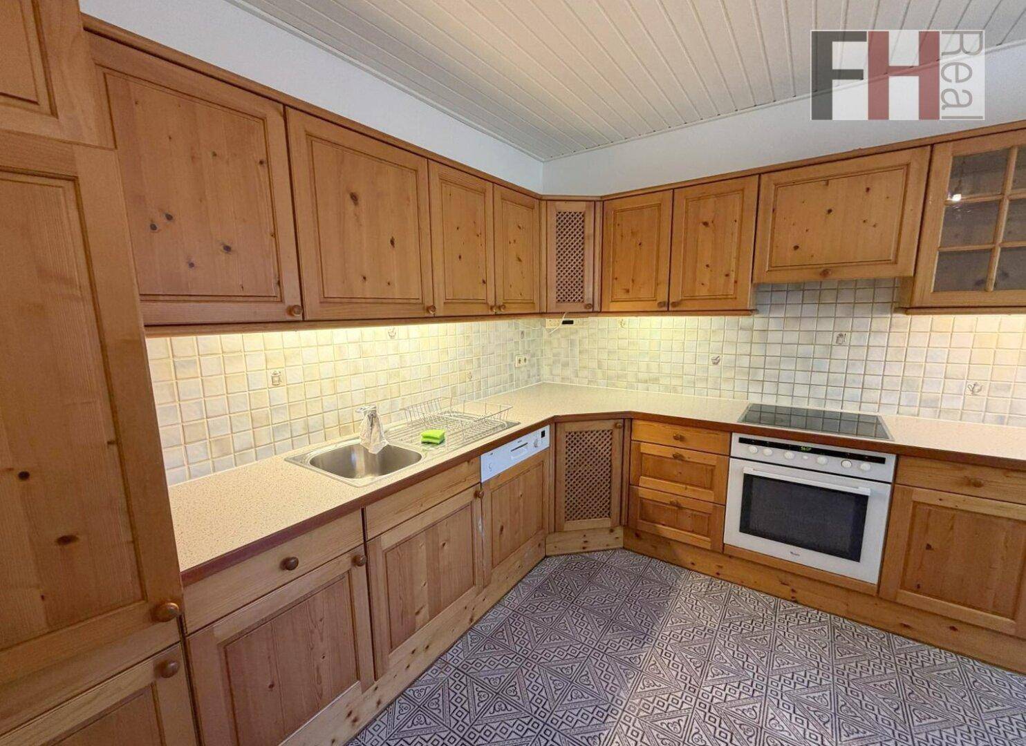 Funktionale Küche mit Holzfronten, integrierten Geräten und ausreichend Arbeitsfläche.