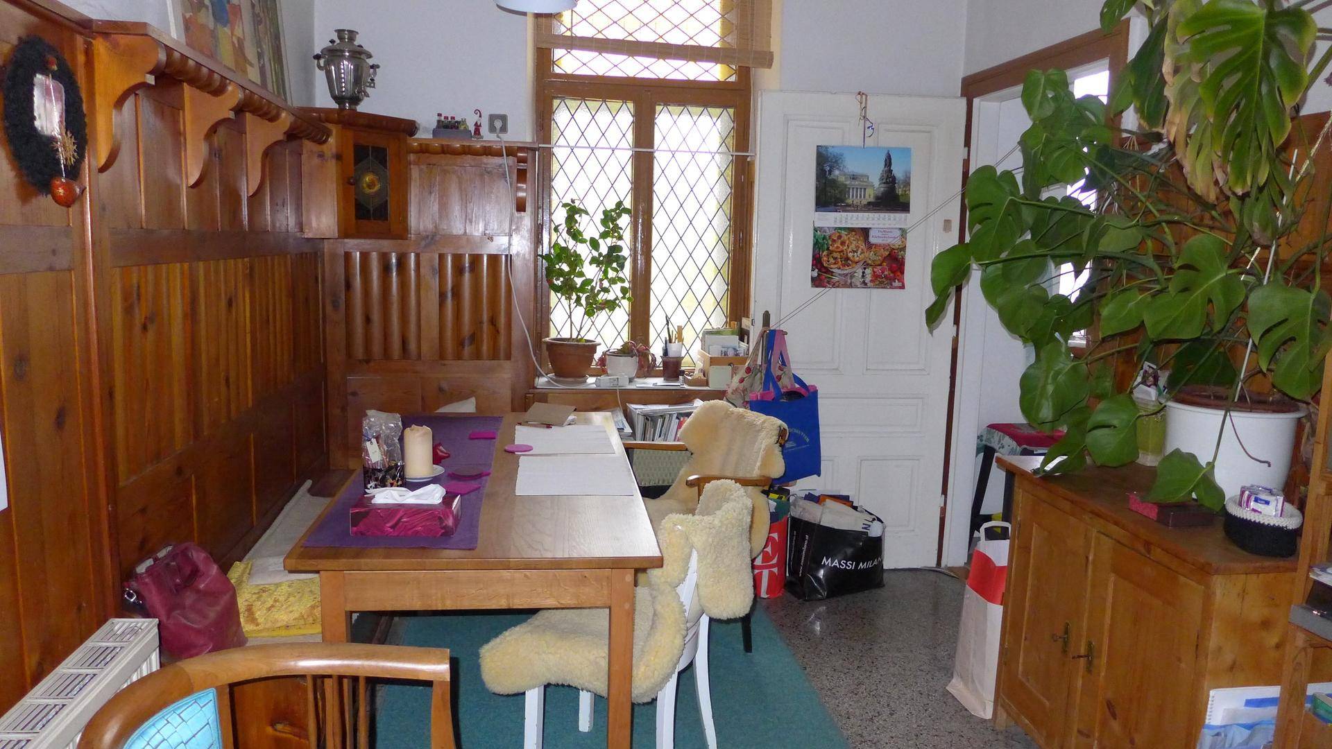 Essbereich oder Arbeitszimmer mit Holzvertäfelung, Holztisch und großem Fenster.