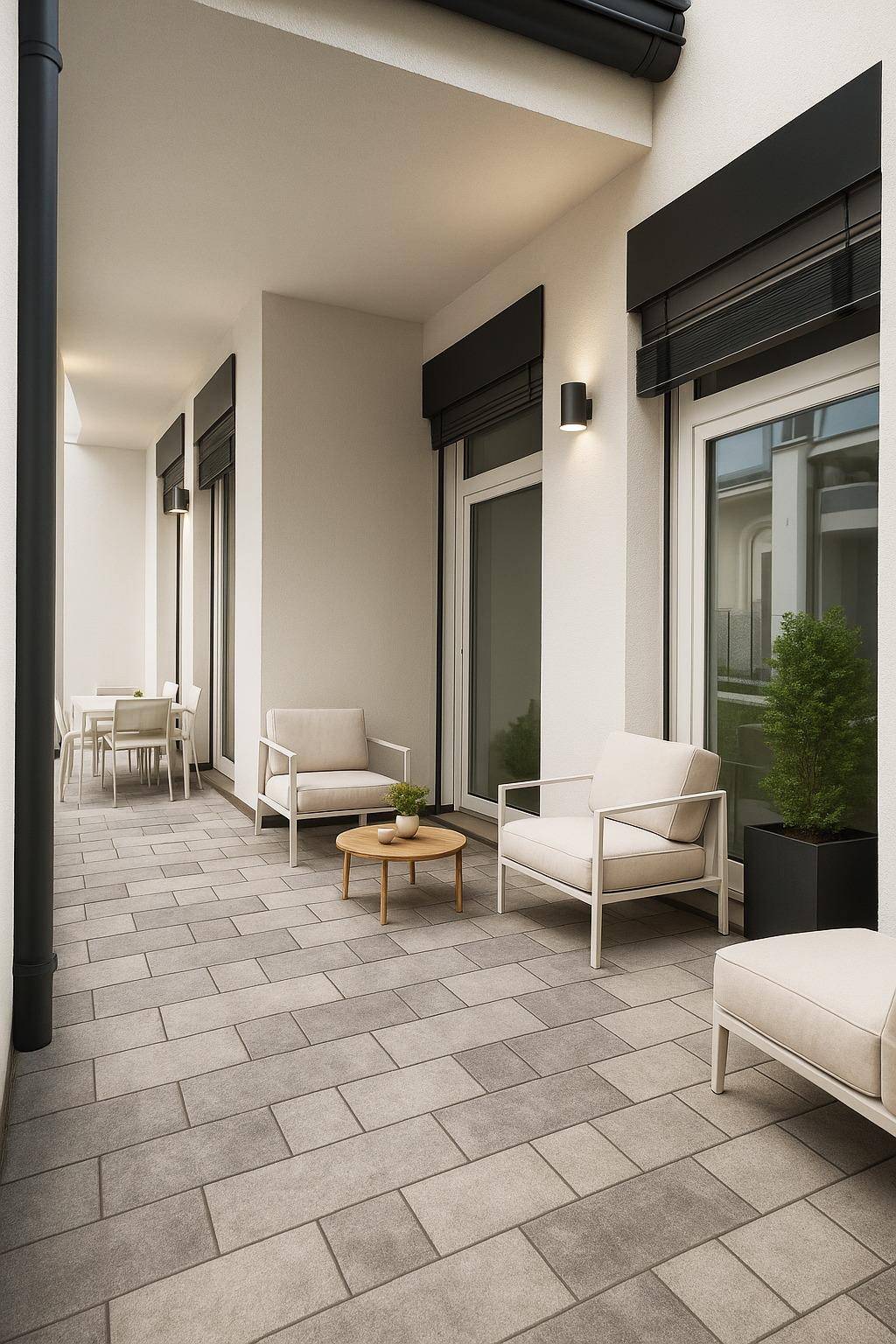 Moderne, geflieste Terrasse mit bequemen Sitzmöbeln und Pflanzen, ideal zum Entspannen.