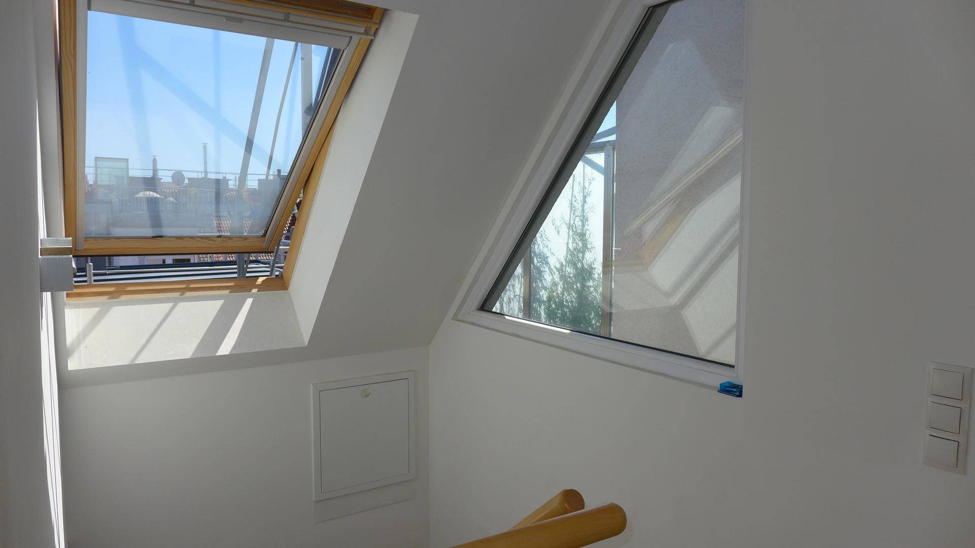 Treppenbereich mit zwei Dachfenstern, die den Raum mit Tageslicht durchfluten.