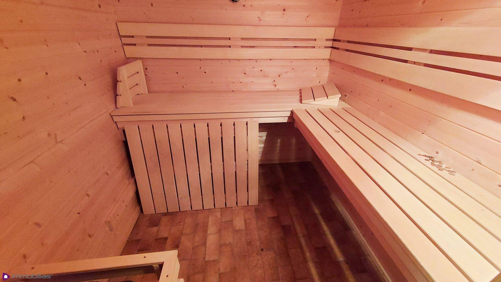 Holzvertäfelte Sauna mit Sitzbänken und traditionellem Design für Entspannung.