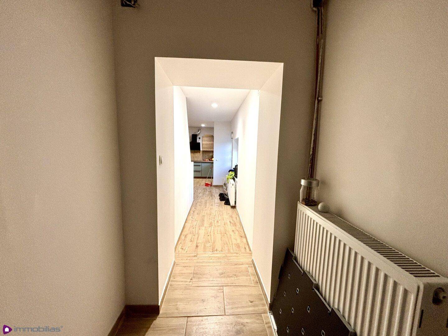 Schmaler Flur mit Fliesenboden, der zu weiteren Räumen führt.