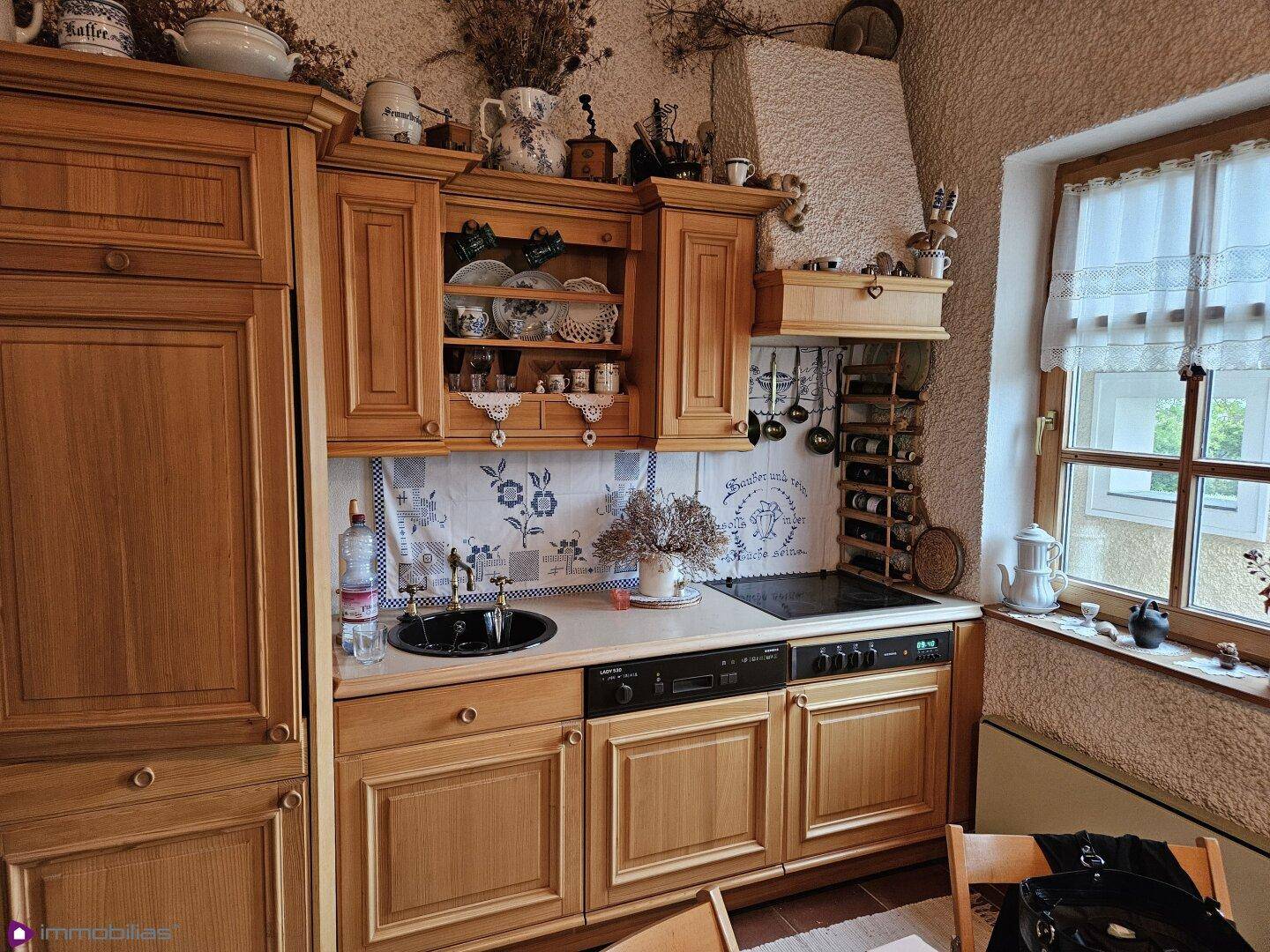 Rustikale Holzküche mit traditionellen Schränken, Spüle und Kochfeld, sehr funktional.