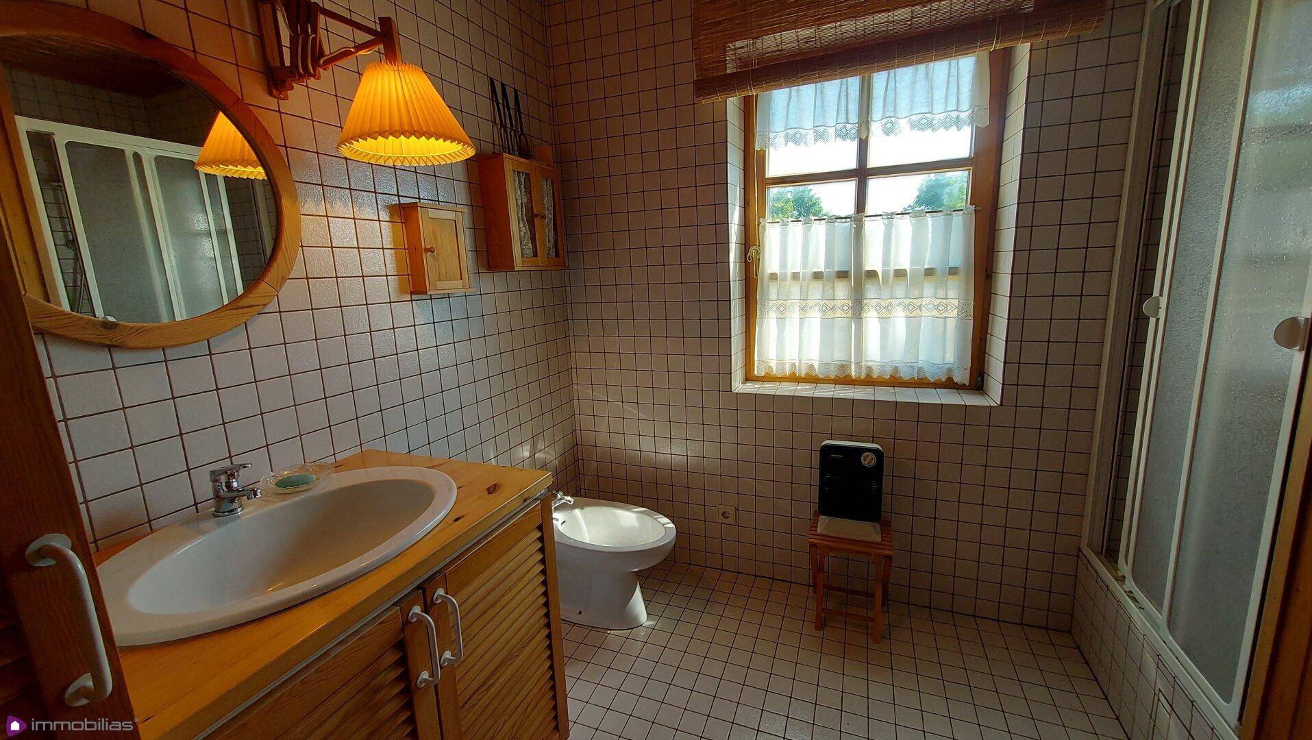 Helles Badezimmer mit Waschbecken, Bidet und Duschkabine, gut beleuchtet.