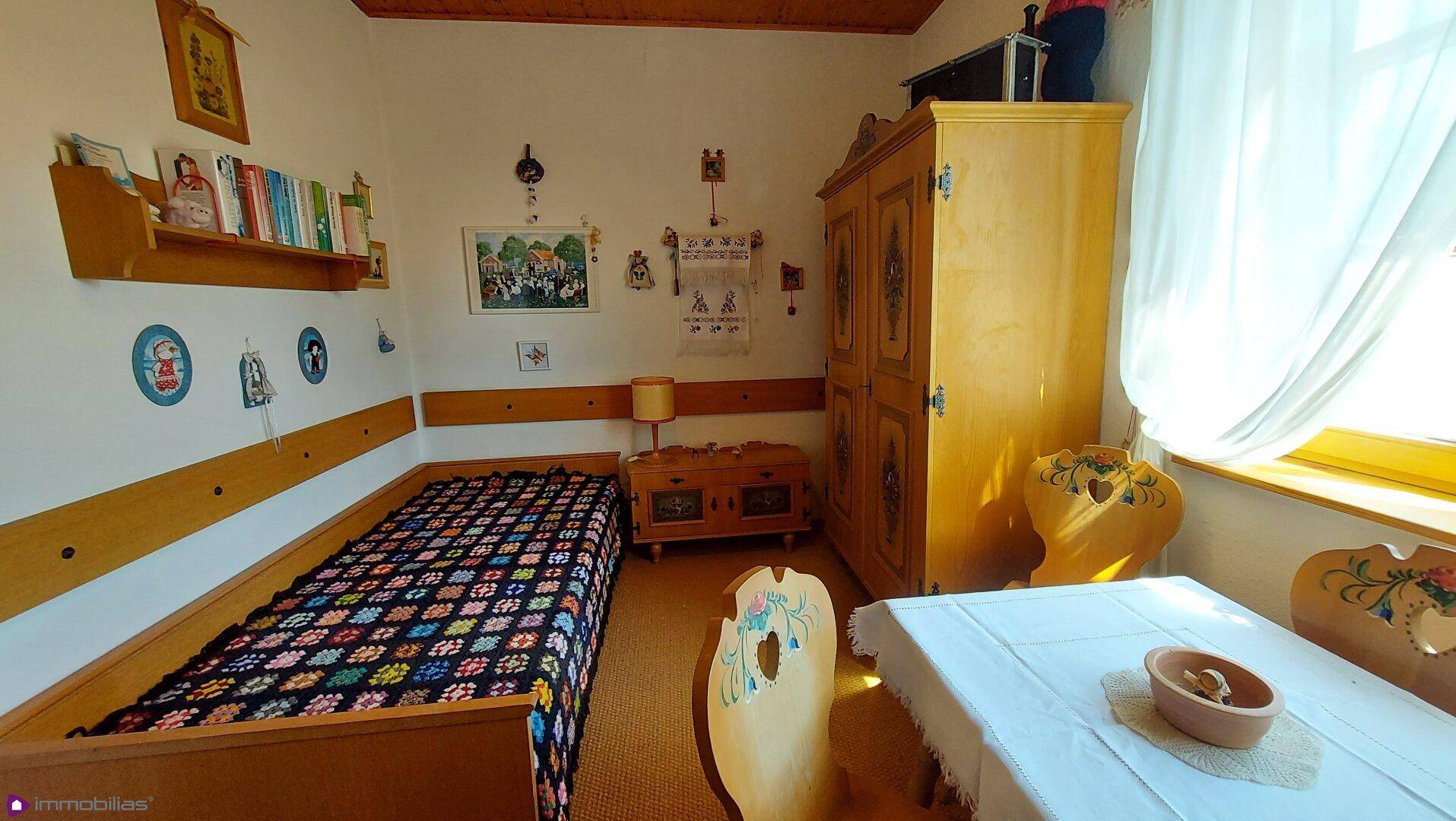 Kinderzimmer oder Gästezimmer mit Einzelbett, Holzboden und traditionellen Möbeln.