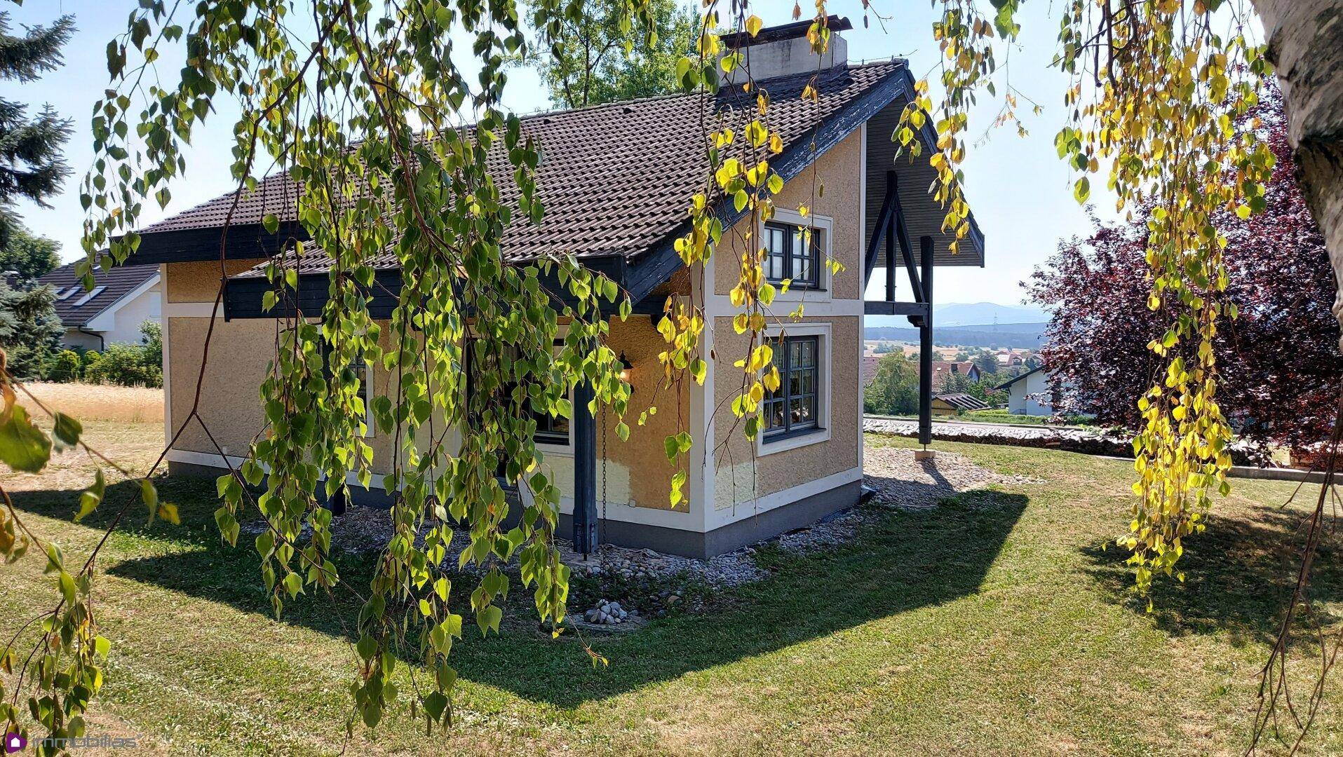 Freistehendes Haus mit Satteldach und Garten in ländlicher Umgebung.