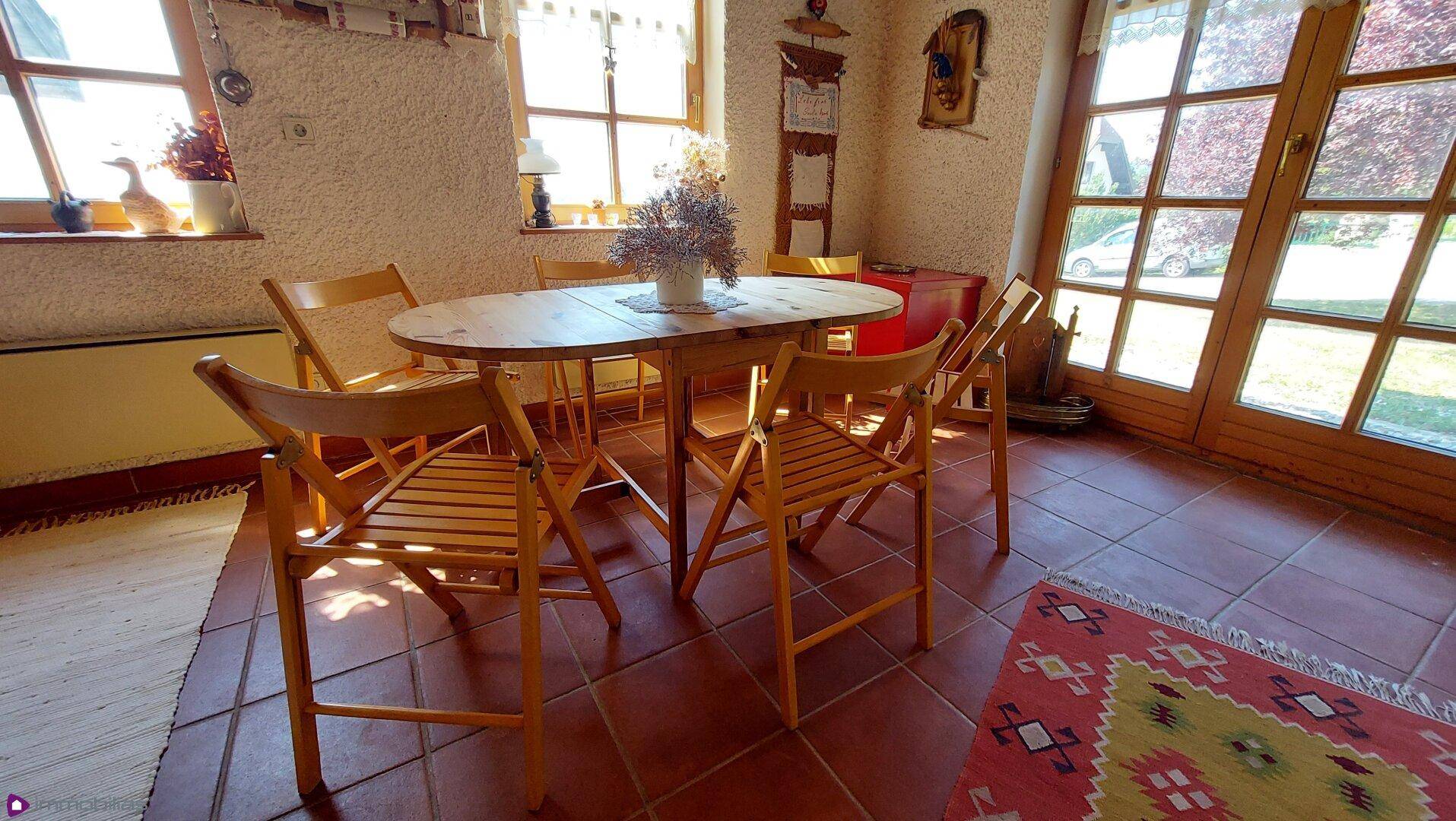 Gemütlicher Essbereich mit Holztisch und Stühlen, direkt an großen Fenstern gelegen.