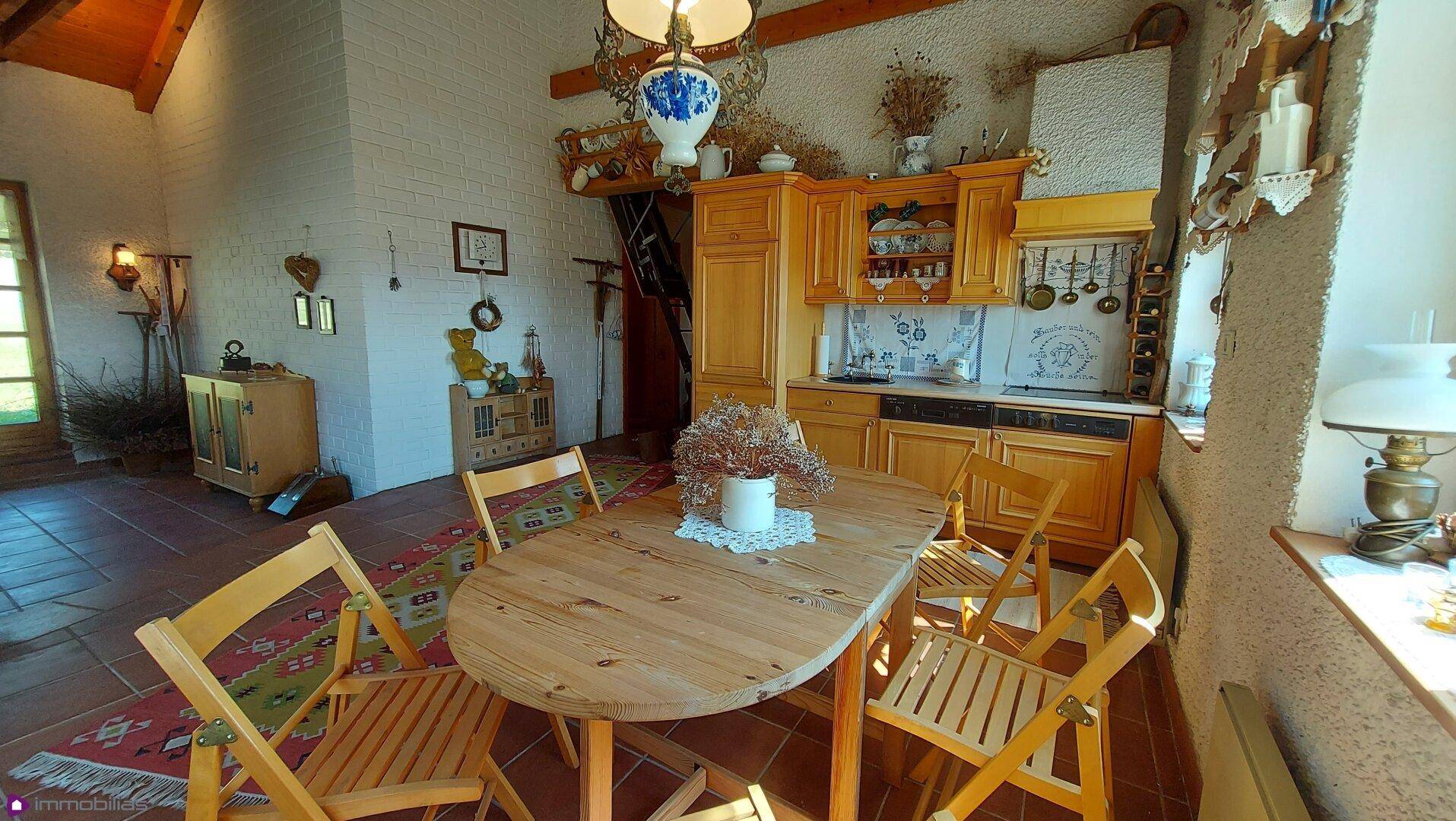 Helle Wohnküche mit Holzeinbauten, Esstisch und Blick auf den Garten.