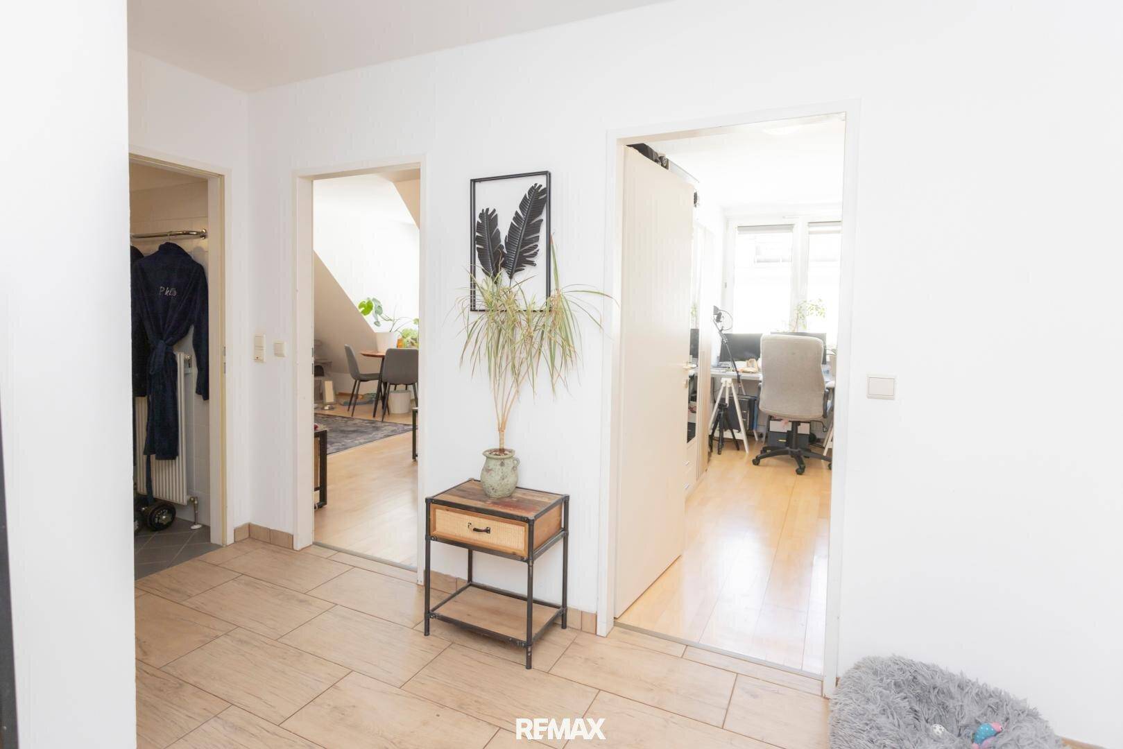 Heller Flur mit hellen Fliesen und Zugang zu verschiedenen Zimmern der Wohnung.