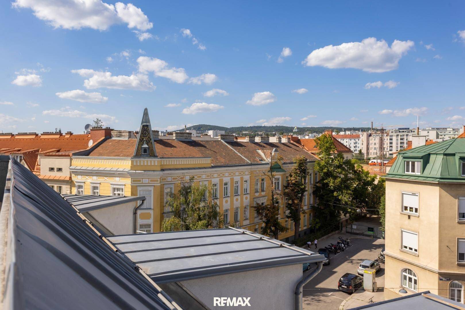 Panoramablick über die historische Stadtarchitektur und belebte Straßen unter blauem Himmel.