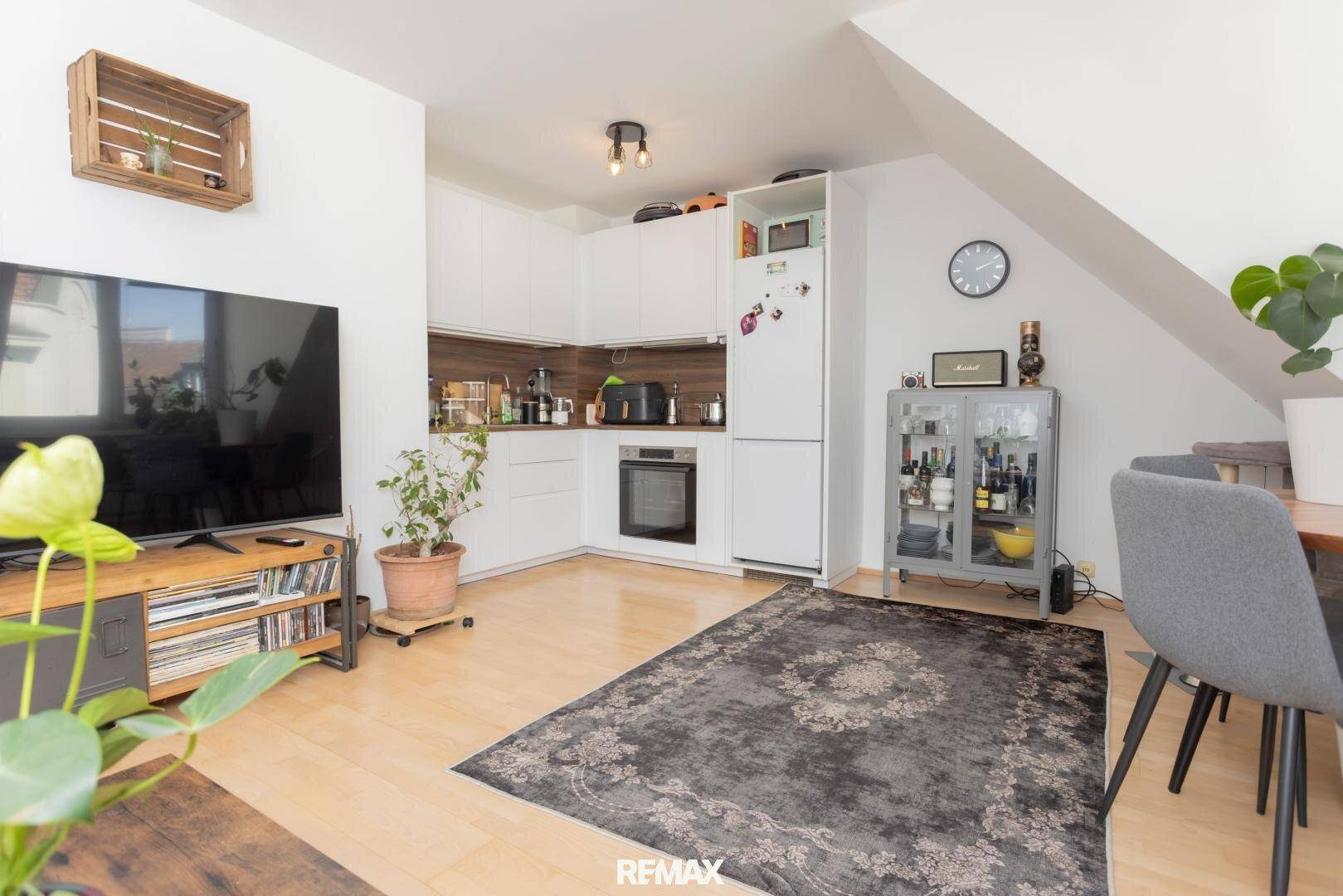 Moderne Einbauküche im offenen Wohnbereich mit Essplatz und Holzboden.