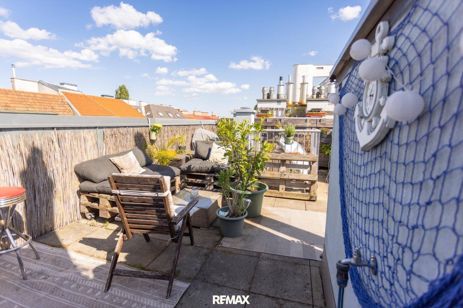 Gemütliche Dachterrasse mit Palettenmöbeln, Pflanzen und maritimer Dekoration für entspannte Stunden.