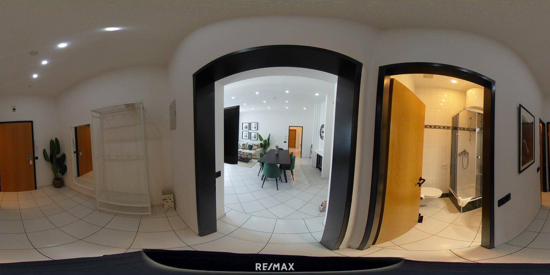 Panoramablick auf den Eingangsbereich mit Zugang zum Wohnzimmer und Badezimmer.