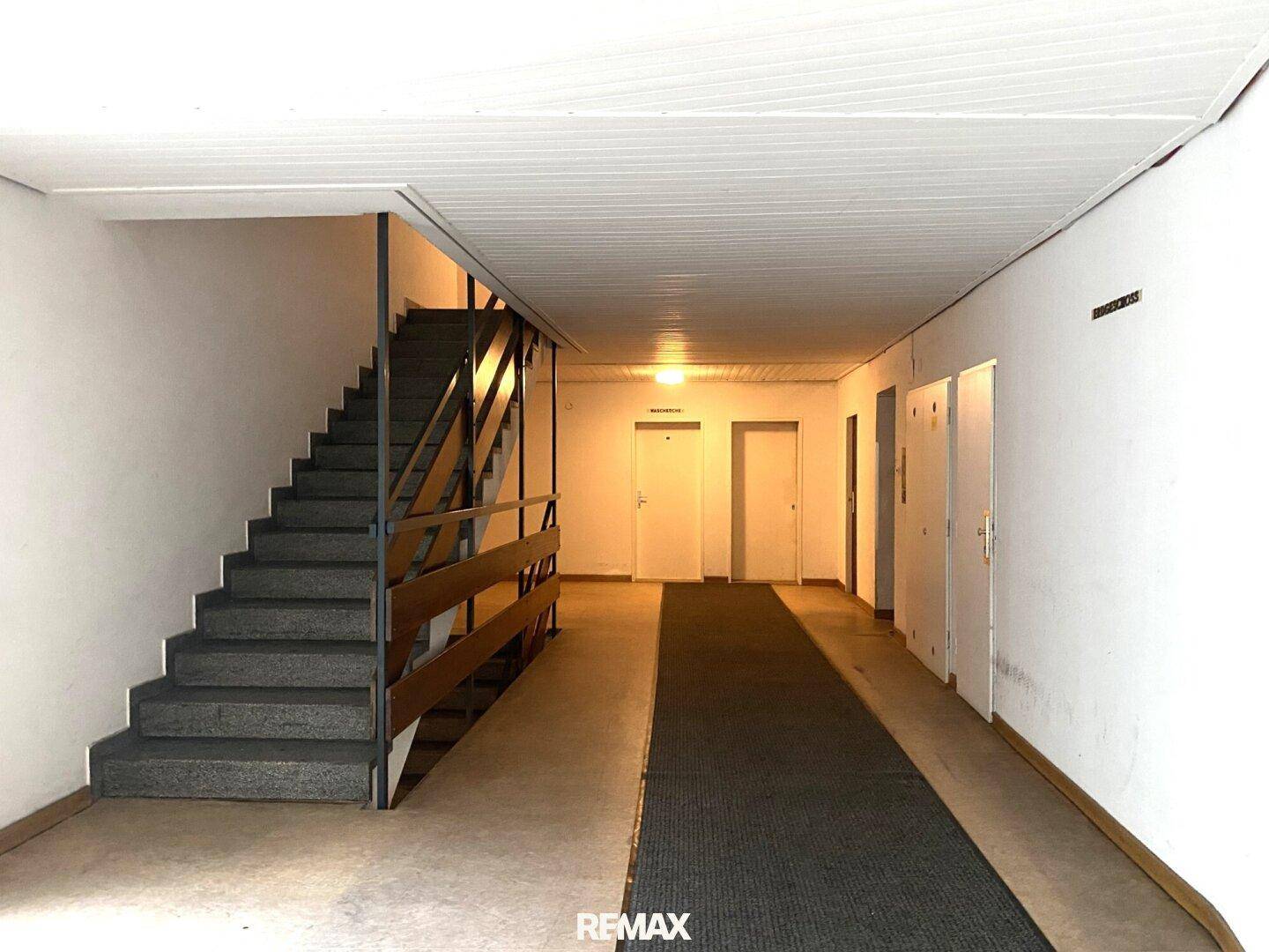 Gemeinschaftlicher Flur mit Treppenaufgang und schlichtem Design im Gebäude.
