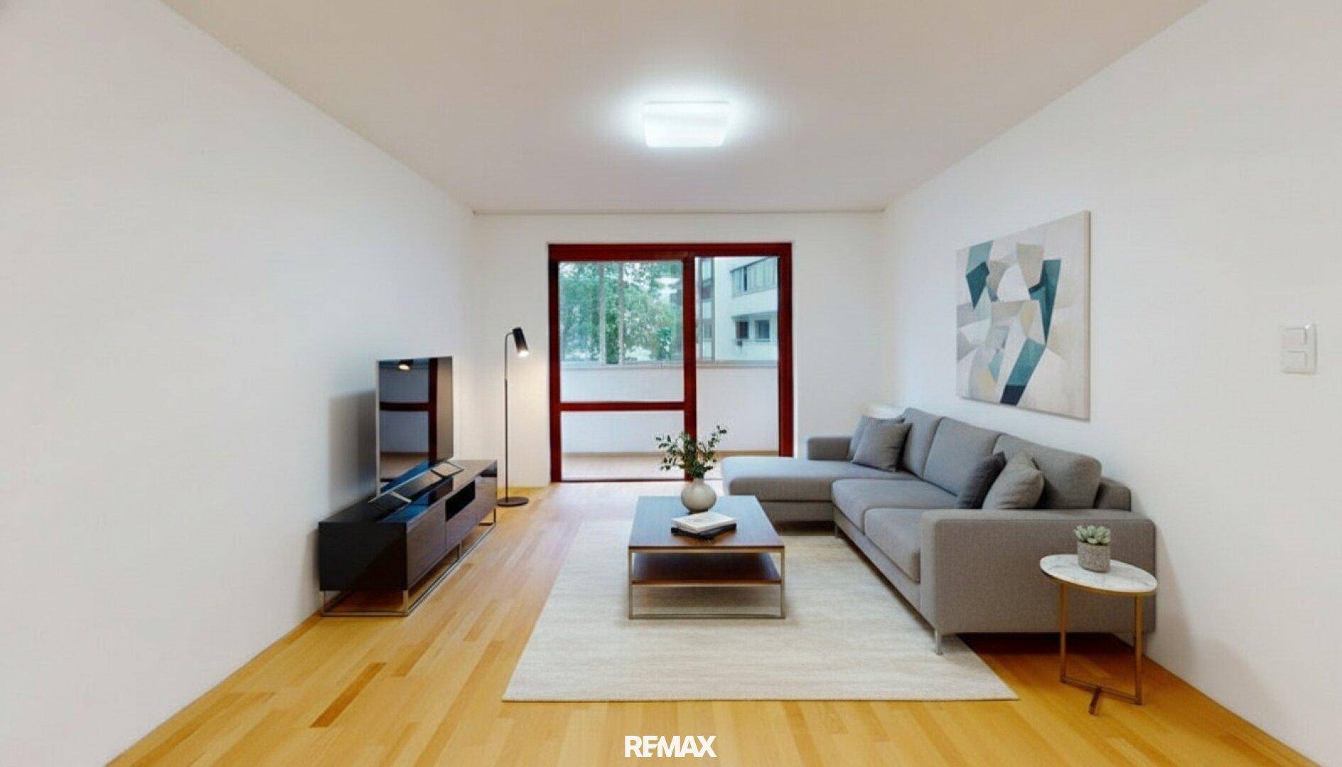 Modern eingerichtetes Wohnzimmer mit hellem Parkettboden, bequemer Couch und Zugang zum Balkon.