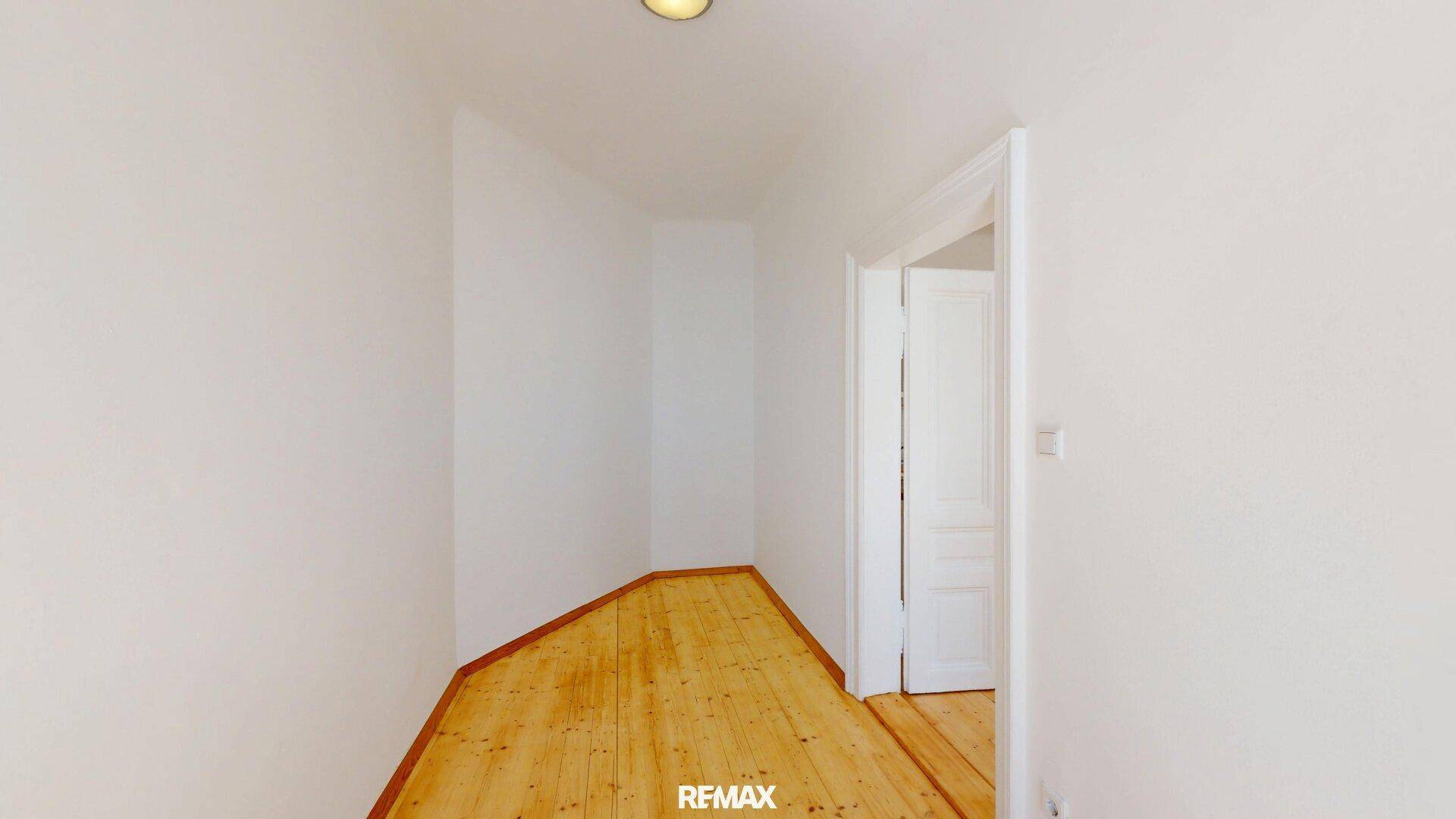 Kleiner, leerer Raum mit Holzboden und weiß gestrichenen Wänden, ideal für verschiedene Nutzungen.
