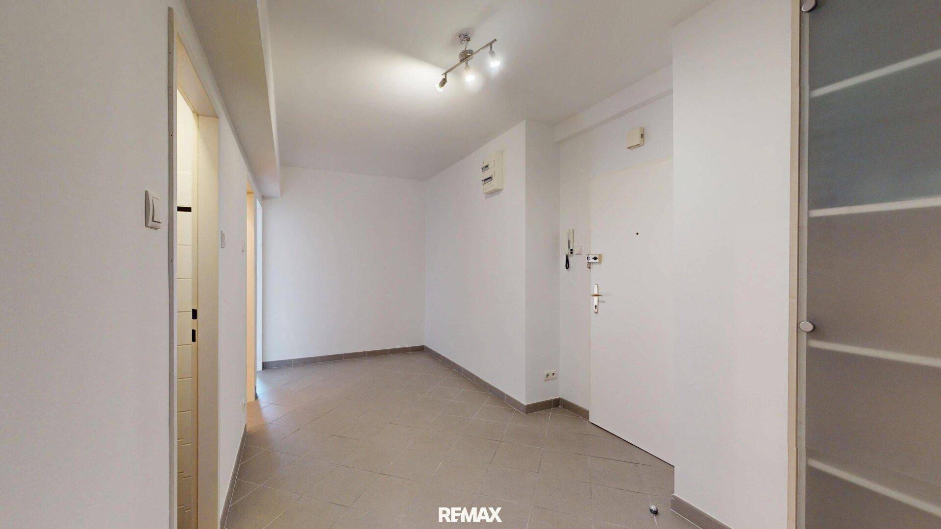 Heller Flur mit Fliesenboden und Zugang zu verschiedenen Räumen der Wohnung.