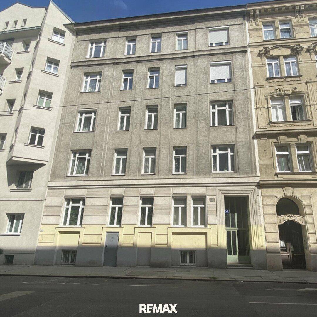 Fassade eines Mehrfamilienhauses mit mehreren Stockwerken und vielen Fenstern.