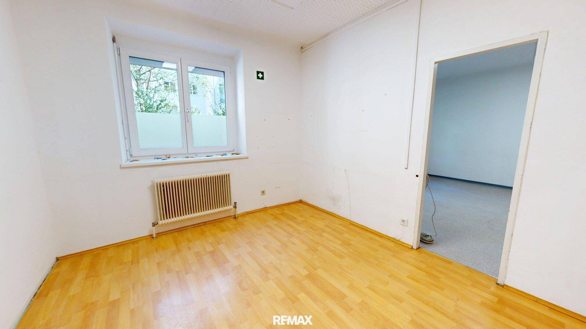 Heller Raum mit Holzfußboden und Fenster, ideal für ein ruhiges Arbeitszimmer.