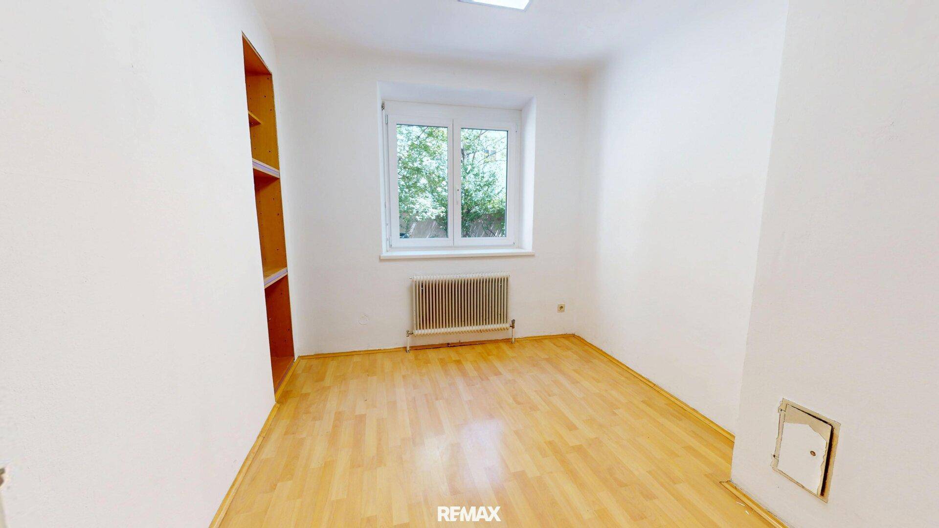 Kleiner Raum mit Holzfußboden und Fenster, ideal als Abstellraum oder kleines Büro.