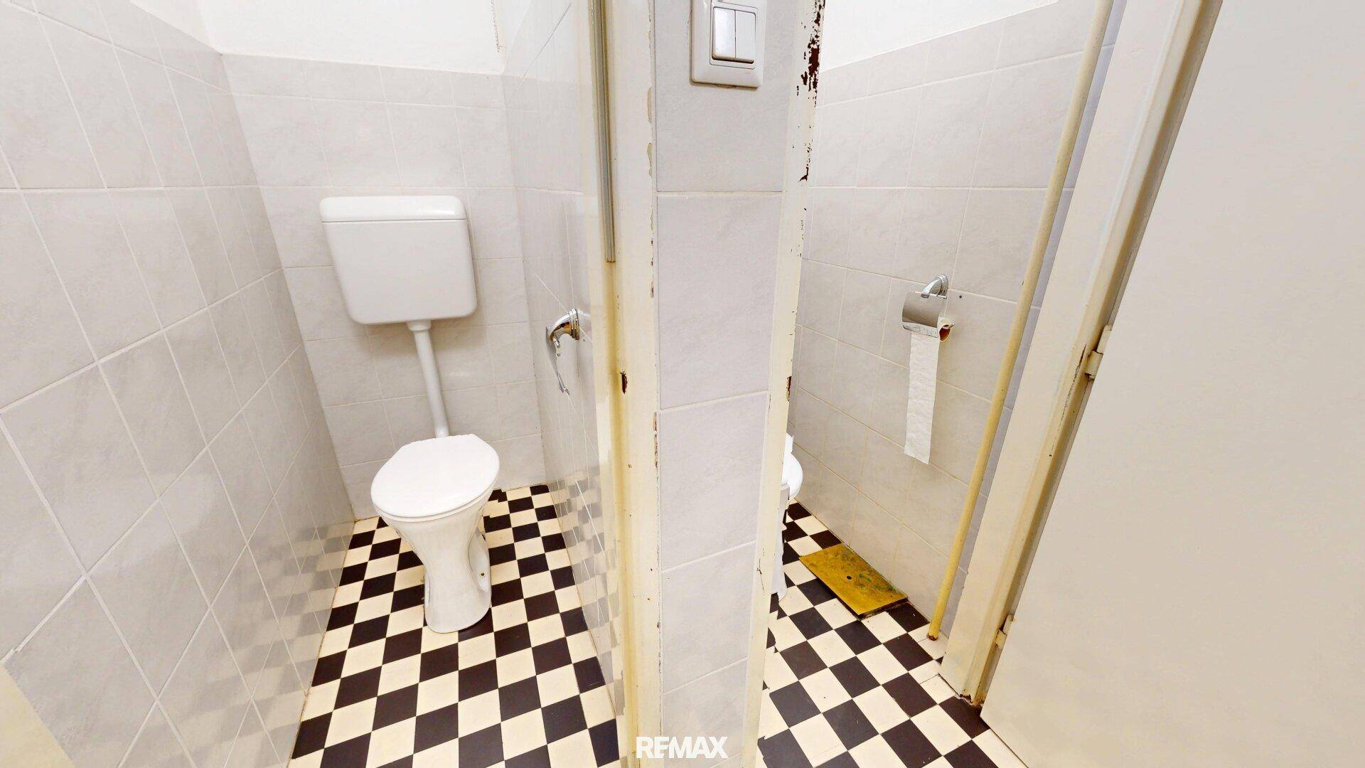 Separate Toilette mit Schachbrettmuster-Fliesenboden und WC, einfach und sauber.