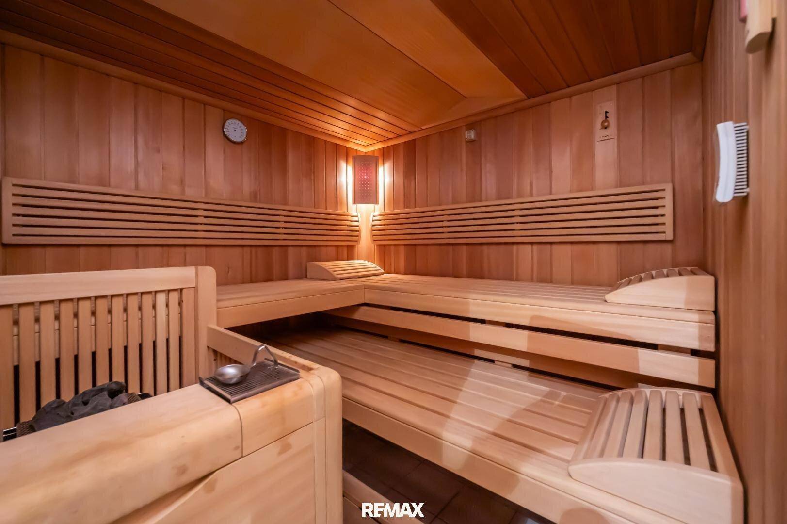 Private Sauna mit Holzverkleidung, Bänken und traditionellem Saunaofen.