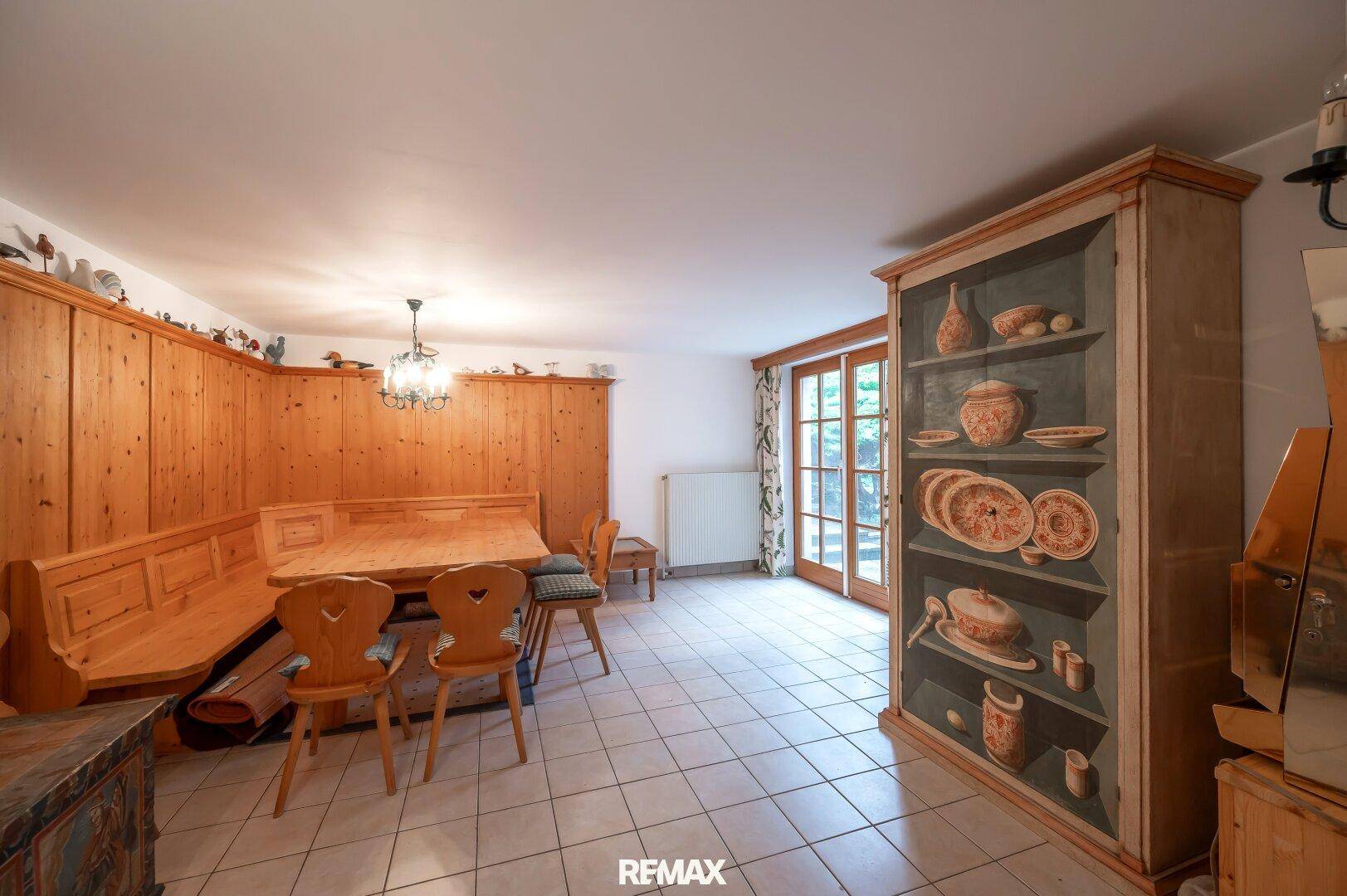 Traditioneller Essbereich mit Holztäfelung, Eckbank und handbemaltem Schrank.