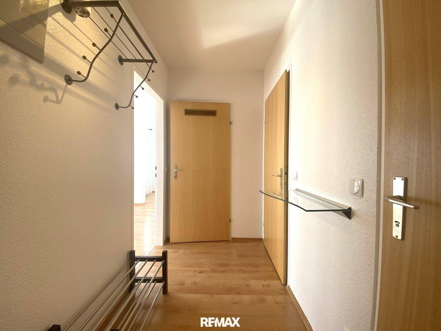 Heller Flur mit Holzboden und Zugang zu verschiedenen Räumen der Wohnung.