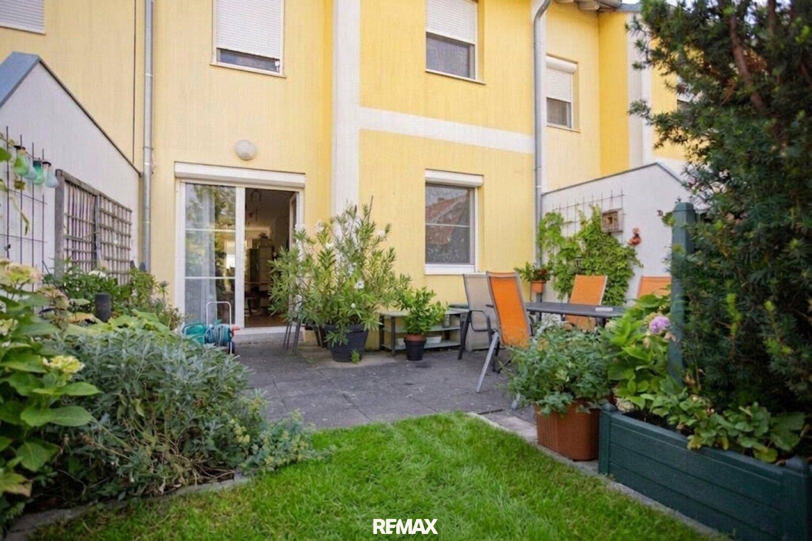 Gemütliche Terrasse mit Gartenmöbeln und direktem Zugang zum Haus sowie Blick auf den Rasen.