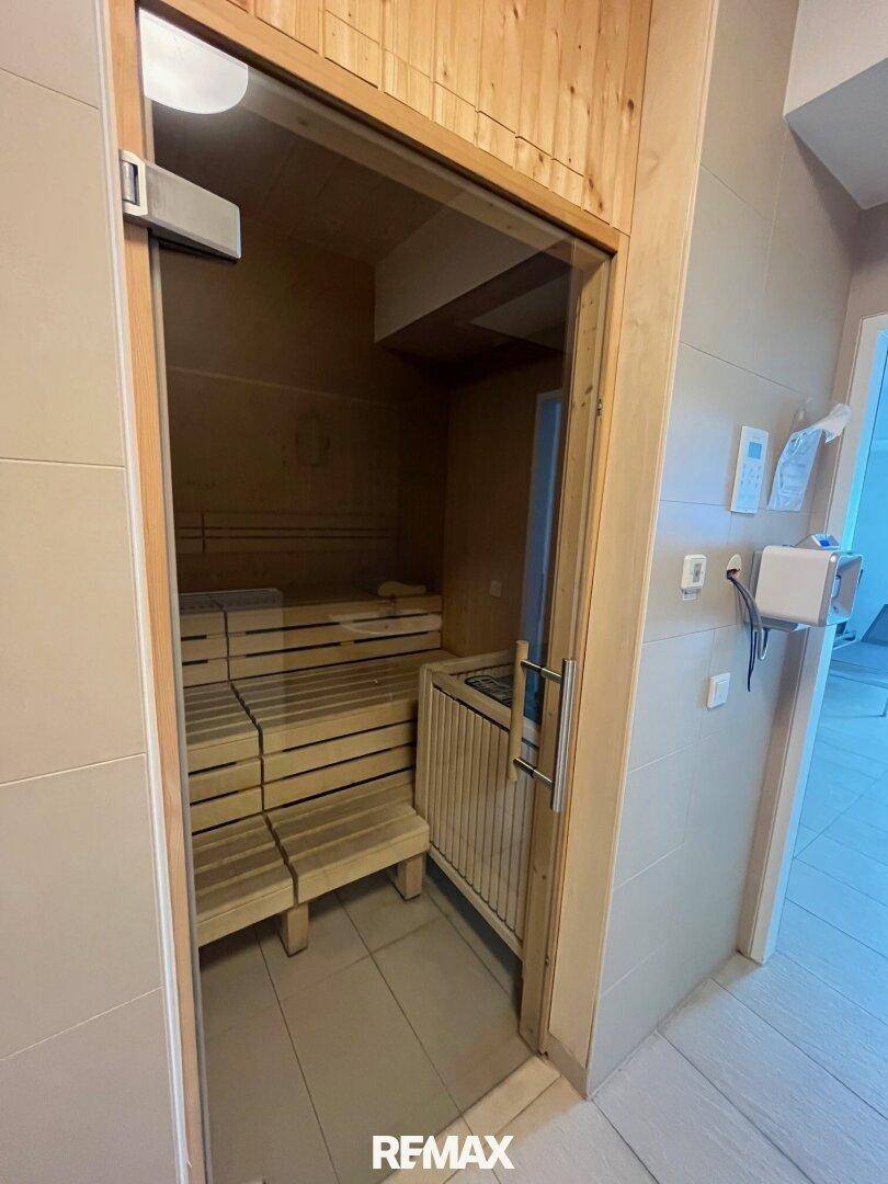 Moderne Sauna mit Holzverkleidung und bequemen Bänken für Entspannung und Wellness.