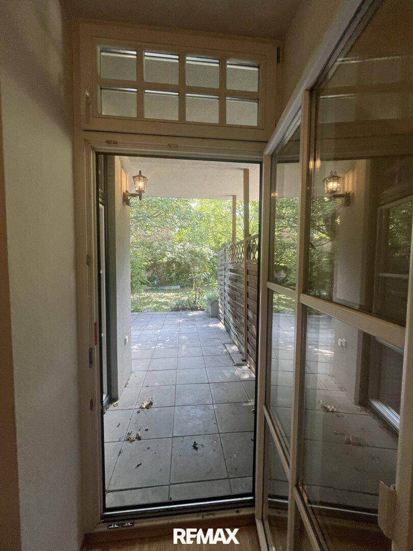 Eingangsbereich mit Blick auf die Außenterrasse und den grünen Garten.