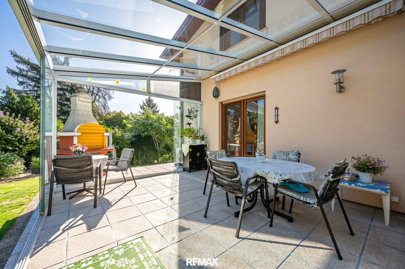 Helle überdachte Terrasse mit Fliesenboden und Essbereich, direkt am Haus gelegen.