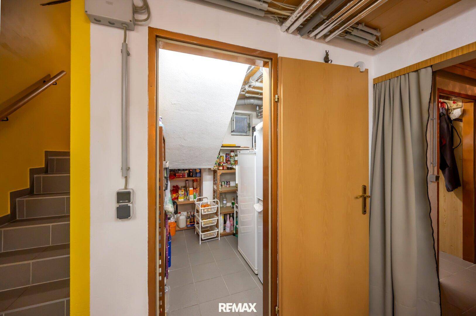 Praktischer Abstellraum im Keller mit Regalen und zusätzlichem Kühlschrank.