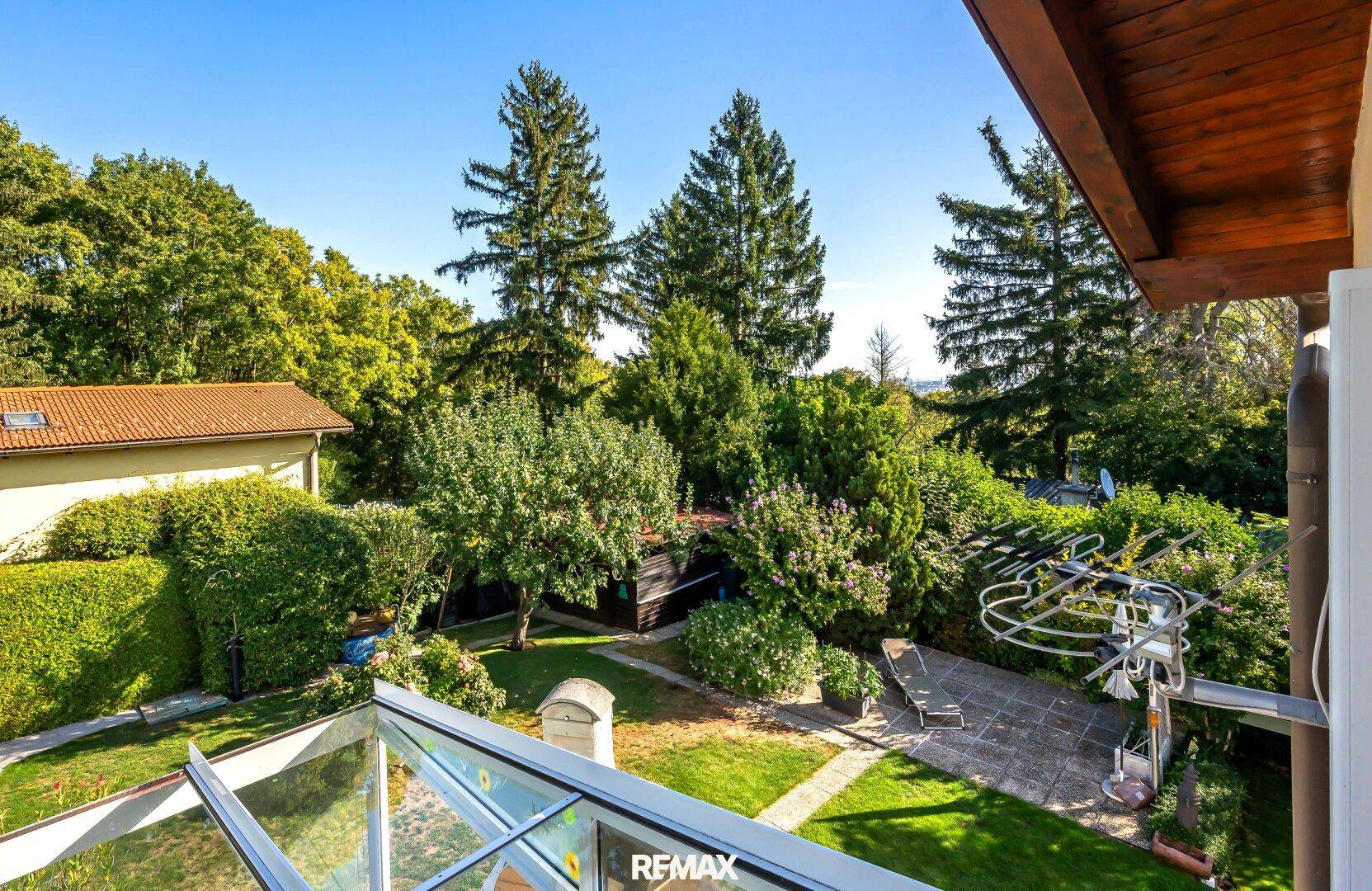 Weitläufiger Blick über den gepflegten Garten mit Bäumen und Sträuchern.