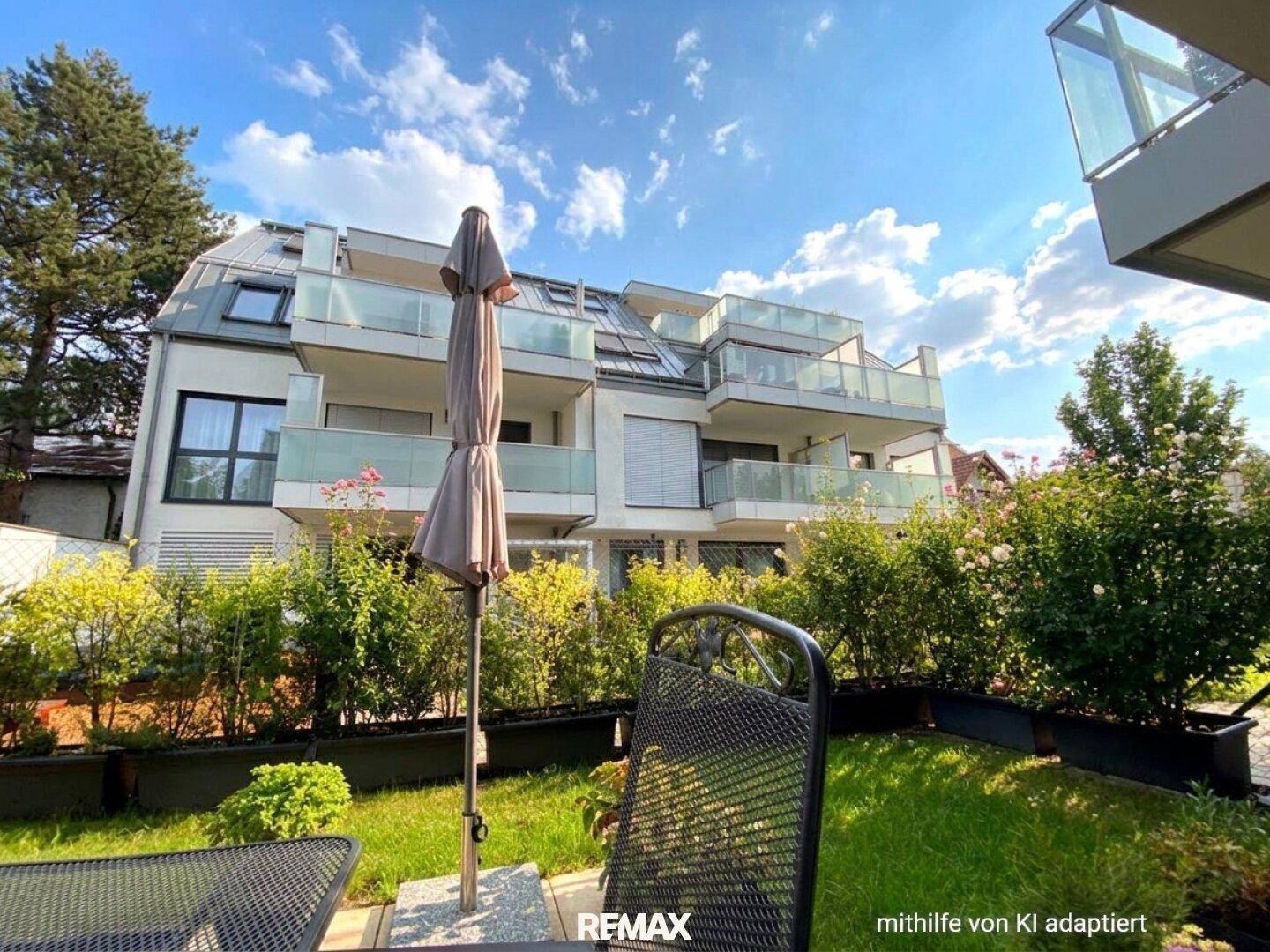 Außenansicht des modernen Gebäudes mit Balkonen und einer Terrasse im Vordergrund.