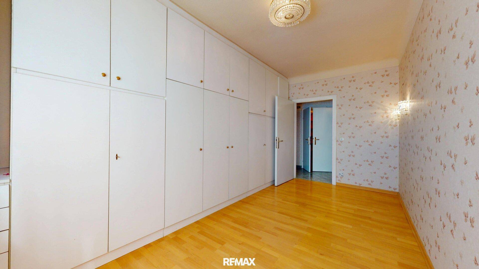Schlafzimmer mit geräumigen Einbauschränken und Parkettboden.
