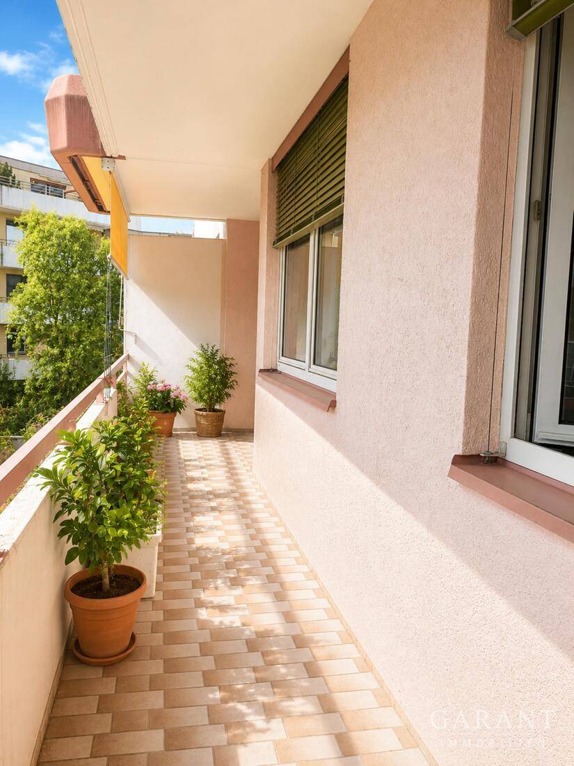 Heller Balkon mit Fliesenboden und Topfpflanzen, bietet eine angenehme Außenfläche.