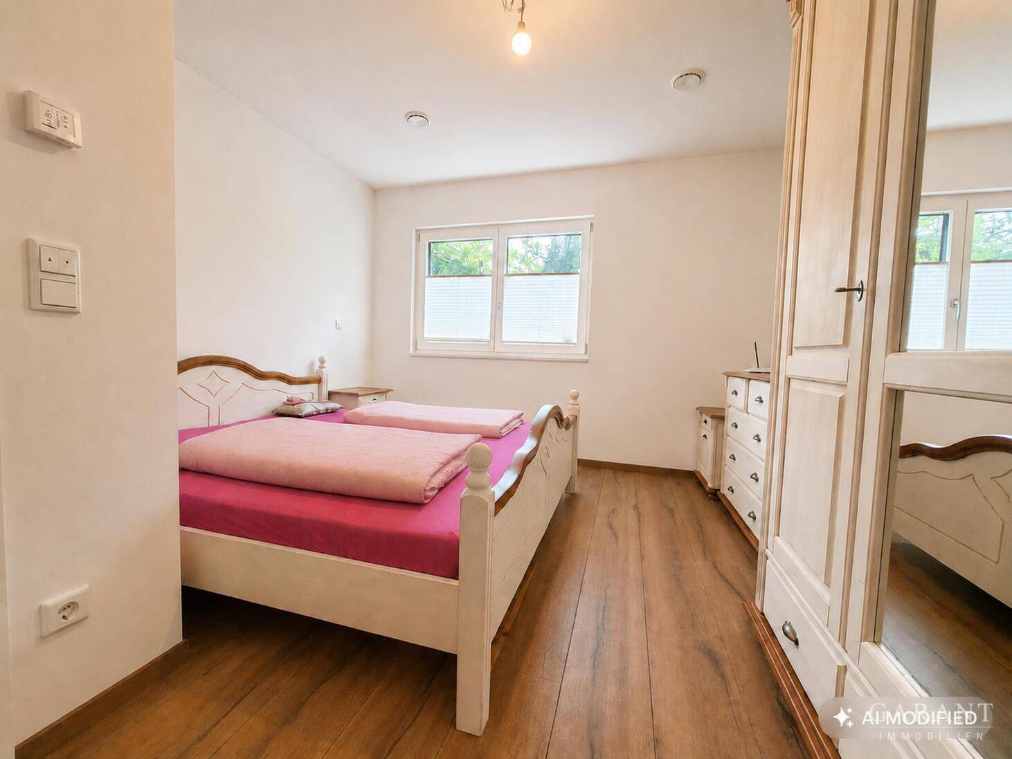 Gemütliches Schlafzimmer mit Doppelbett, Holzschrank und Fenster.