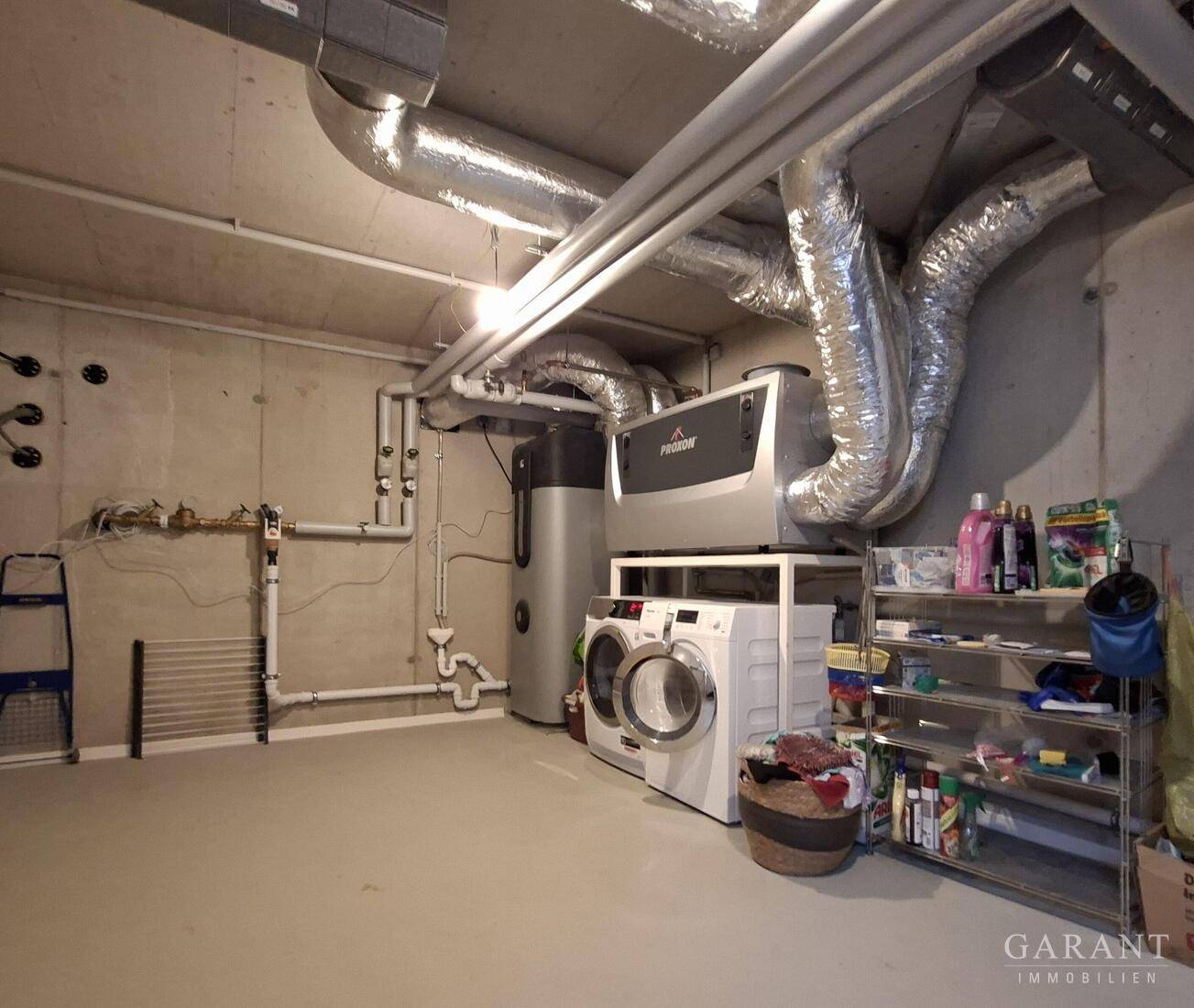 Technikraum im Keller mit Heizungsanlage, Waschmaschine und Trockner.