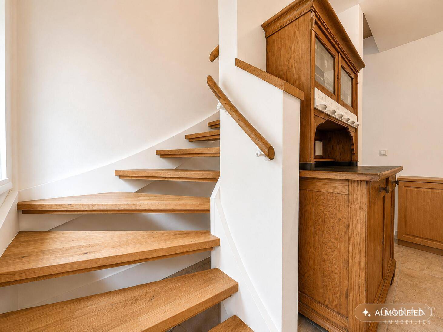 Holztreppe mit offenem Design und antiker Kommode im Eingangsbereich.