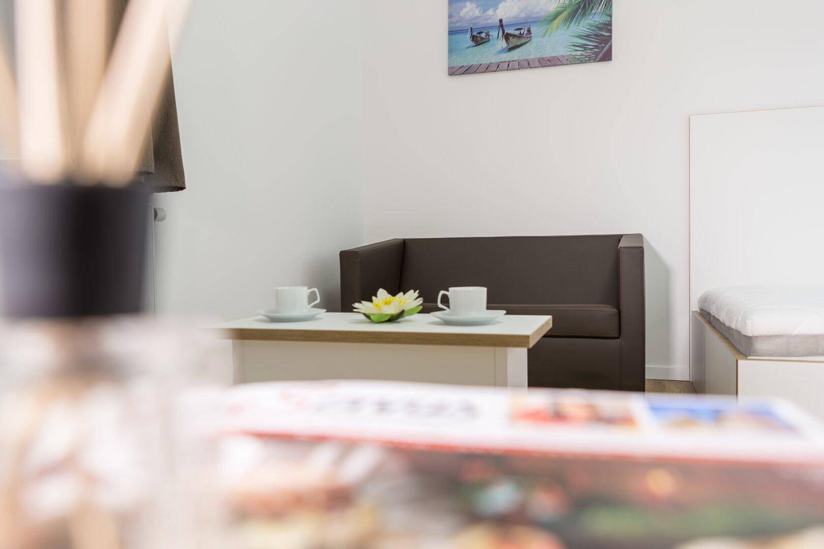 Gemütlicher Wohnbereich mit kleinem Sofa und Couchtisch, ideal zum Entspannen.