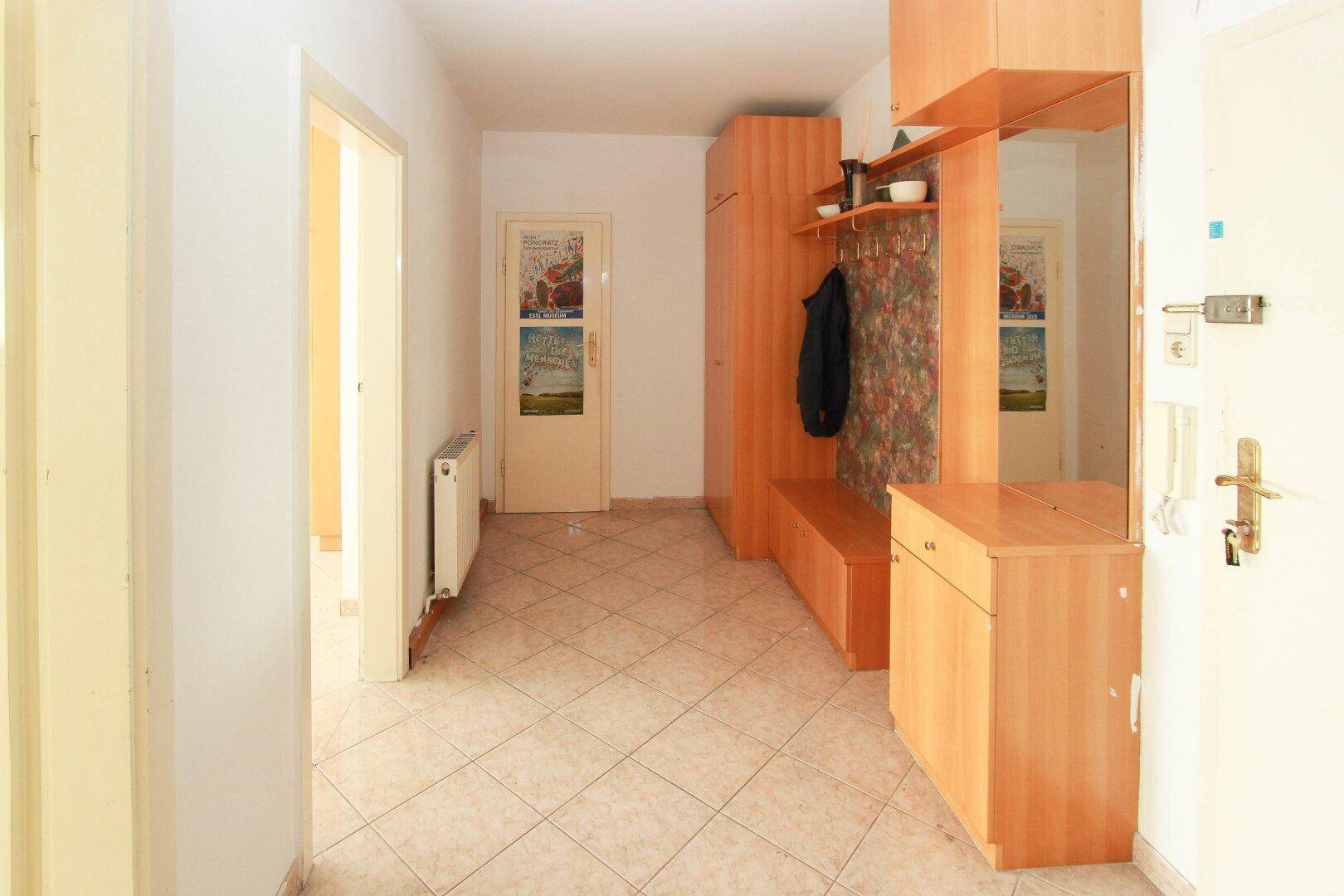 Eingangsbereich mit Fliesenboden und Garderobe, die praktischen Stauraum bietet.