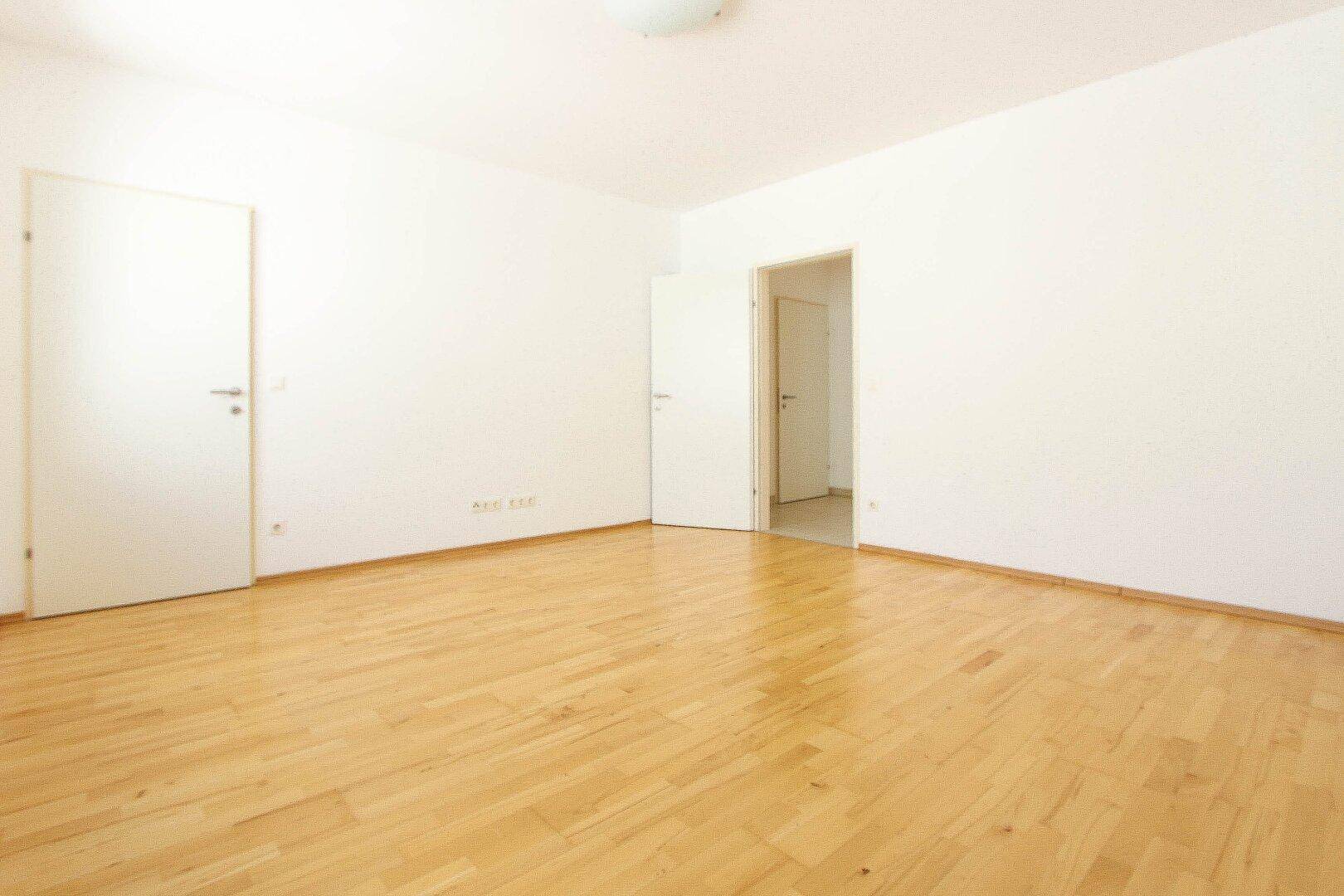 Geräumiges, helles Zimmer mit Parkettboden und zwei Türen, bietet vielseitige Nutzungsmöglichkeiten.